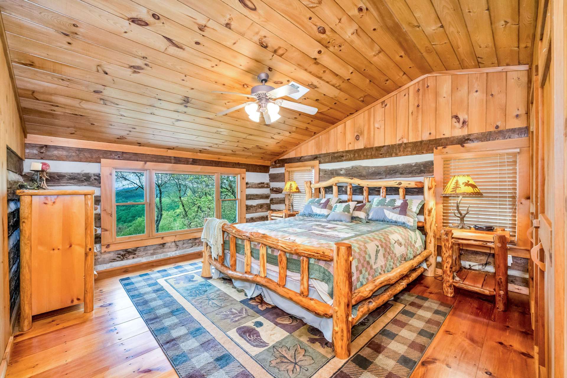 A private guest bedroom is a rejuvenating retreat with inspiring views through a picture window of the soaring mountain tops.