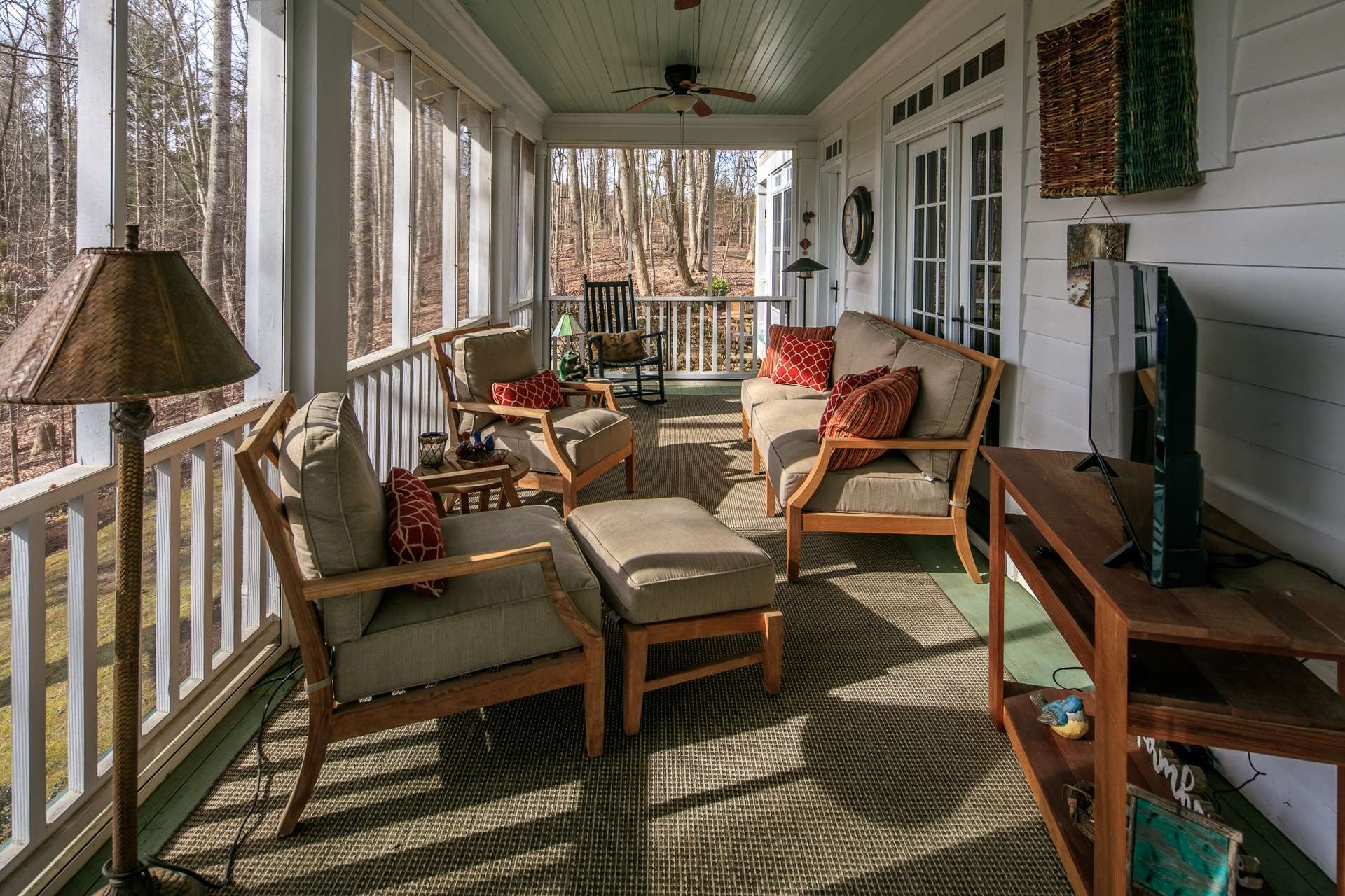This home offers multiple outdoor living spaces including this covered and screened back porch expanding the living space during warmer months.