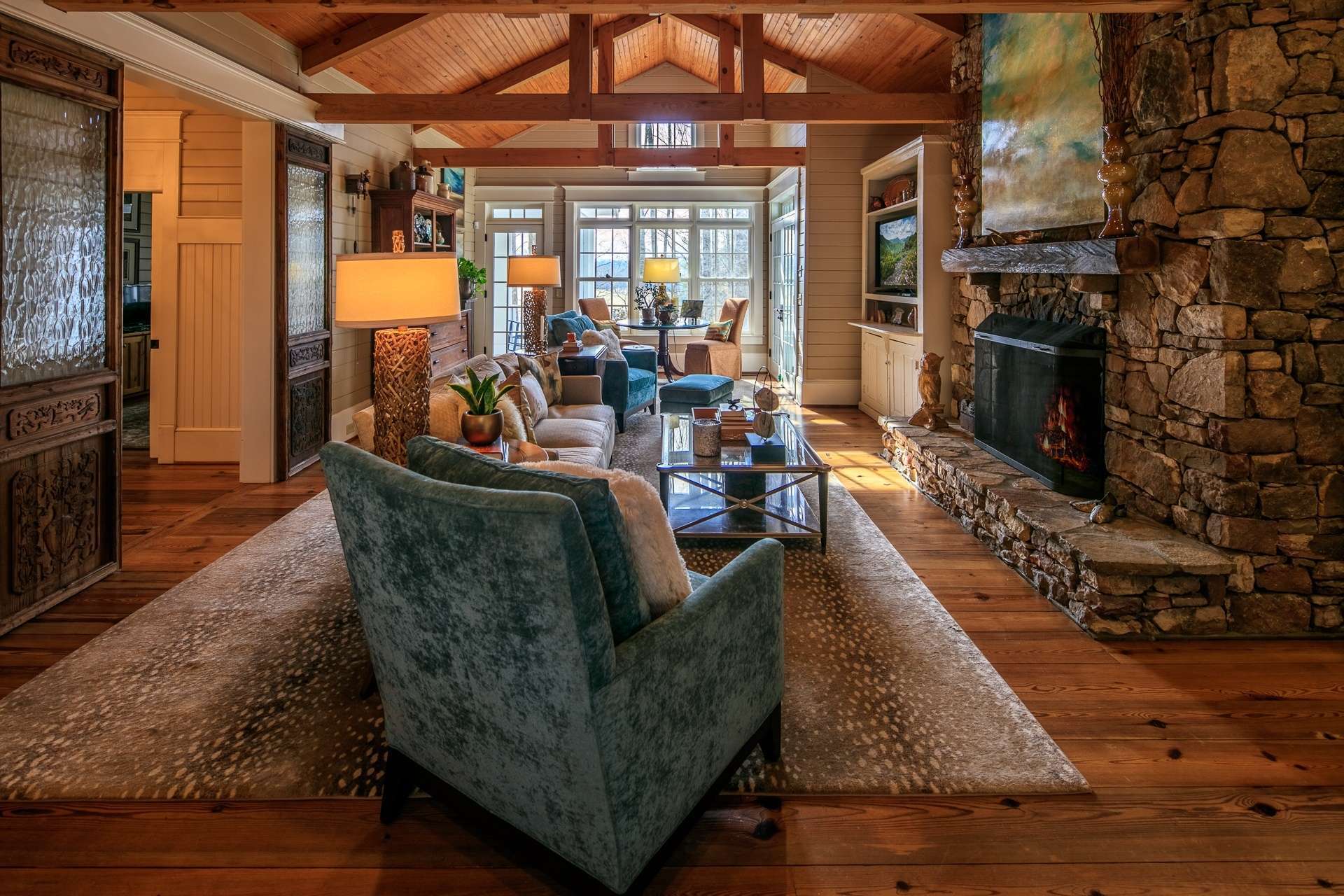 The native stone fireplace with gas logs adds warmth on cool winter evenings while the reclaimed wood flooring and heirloom doors enhance the farmhouse styling and custom appointments.