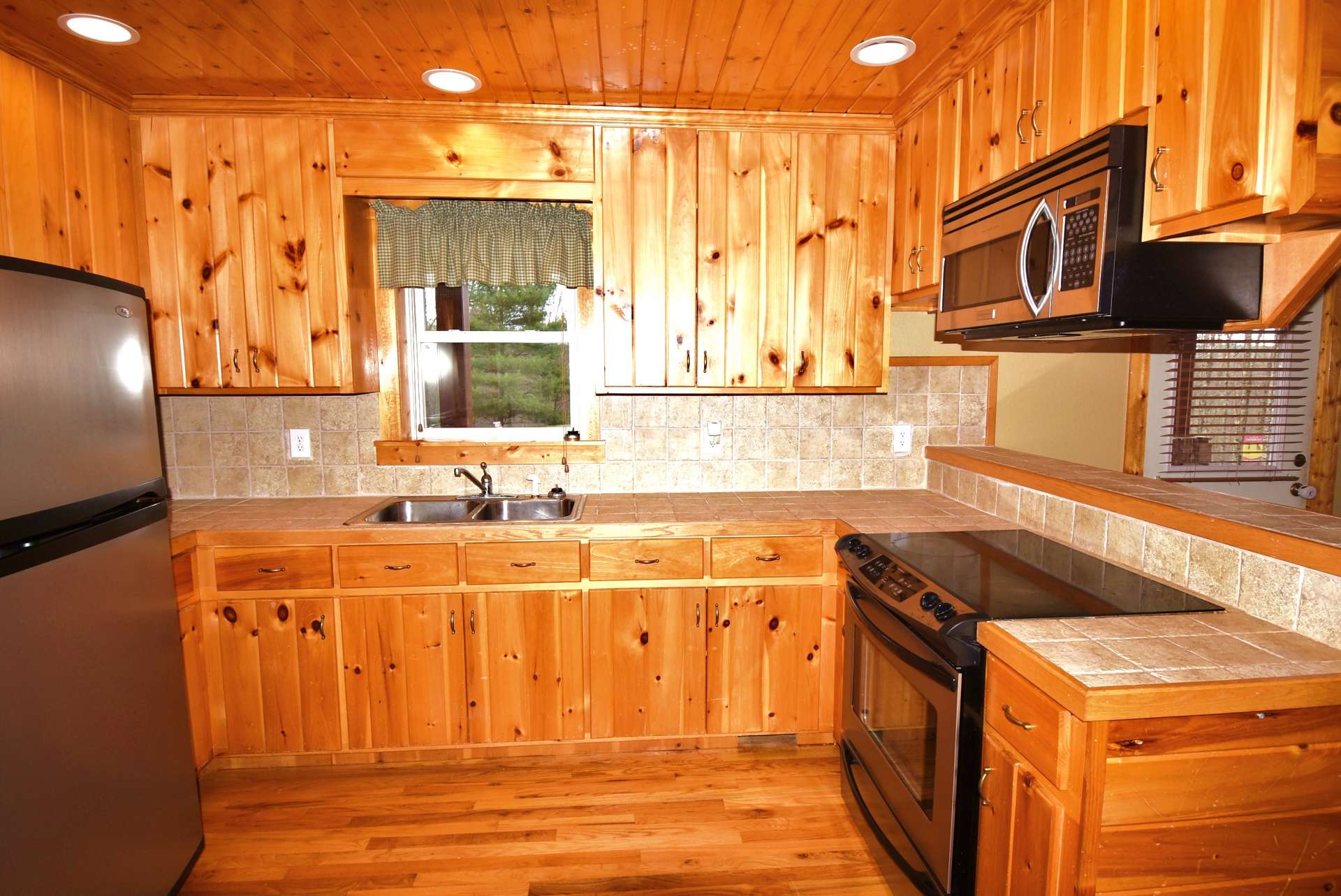 The kitchen offers plenty of work and storage space and a bar with seating space for informal dining.
