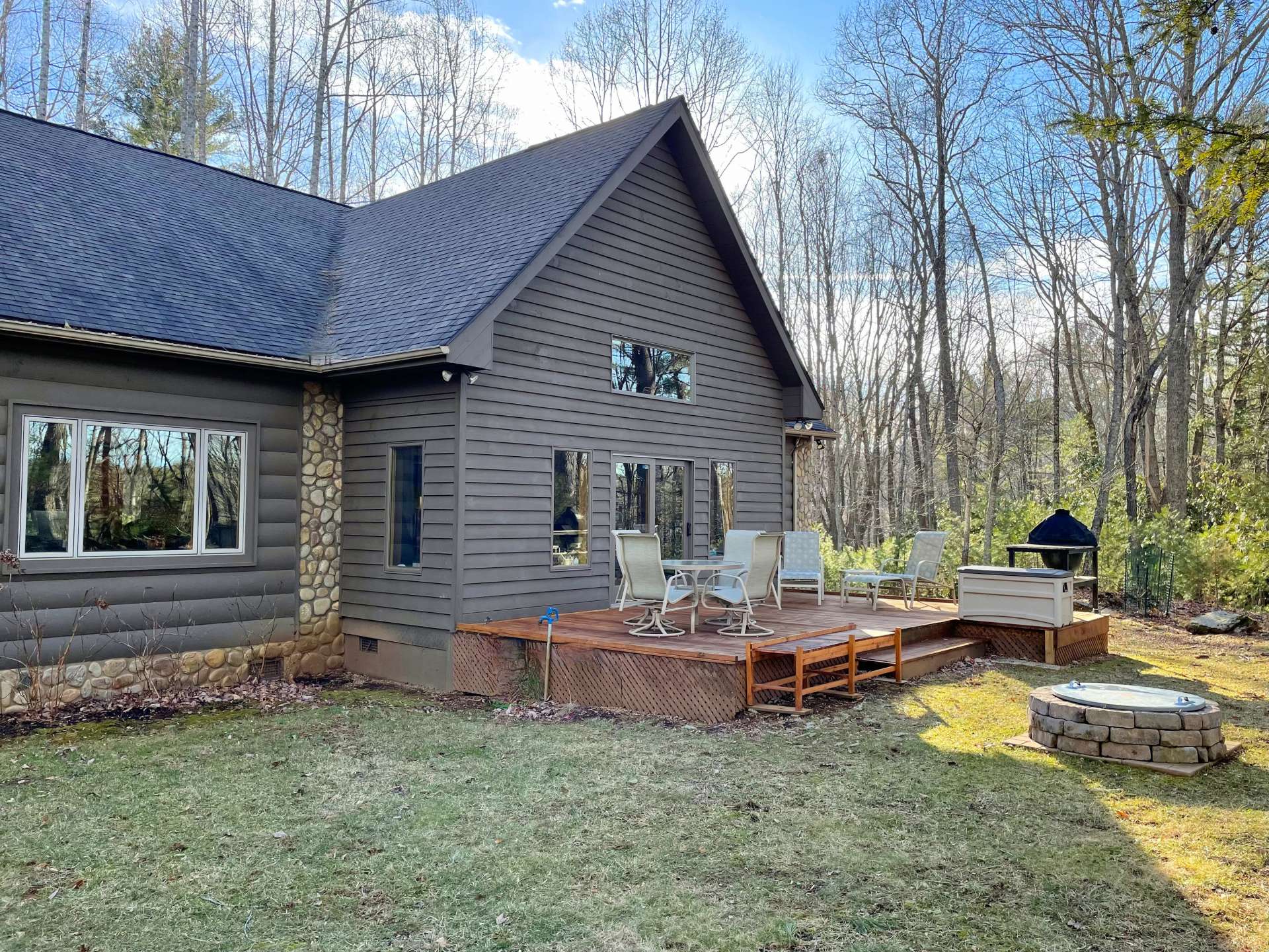 View of the Back deck and yard with fire pit area.