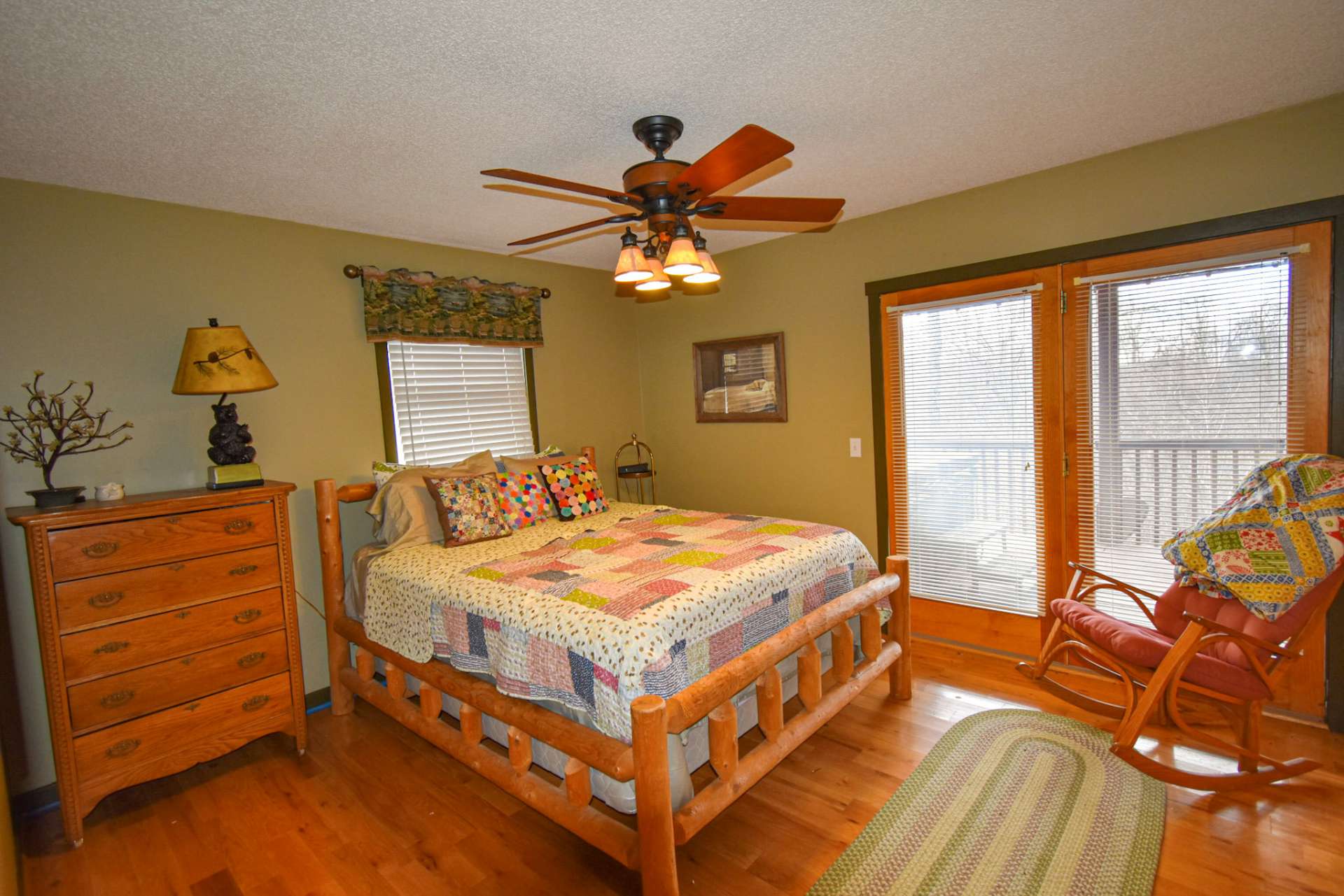 The main level bedroom features hardwood floors and private access to the covered deck.