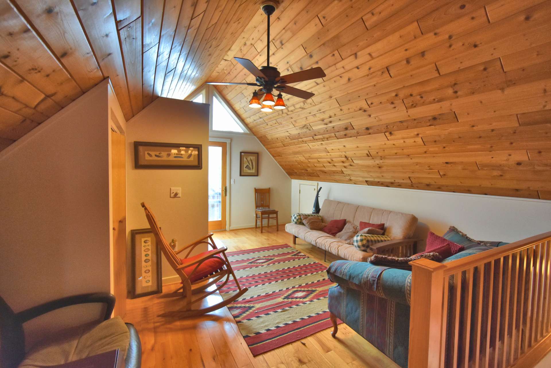 The large sleeping loft features access to a private balcony and a full bath.