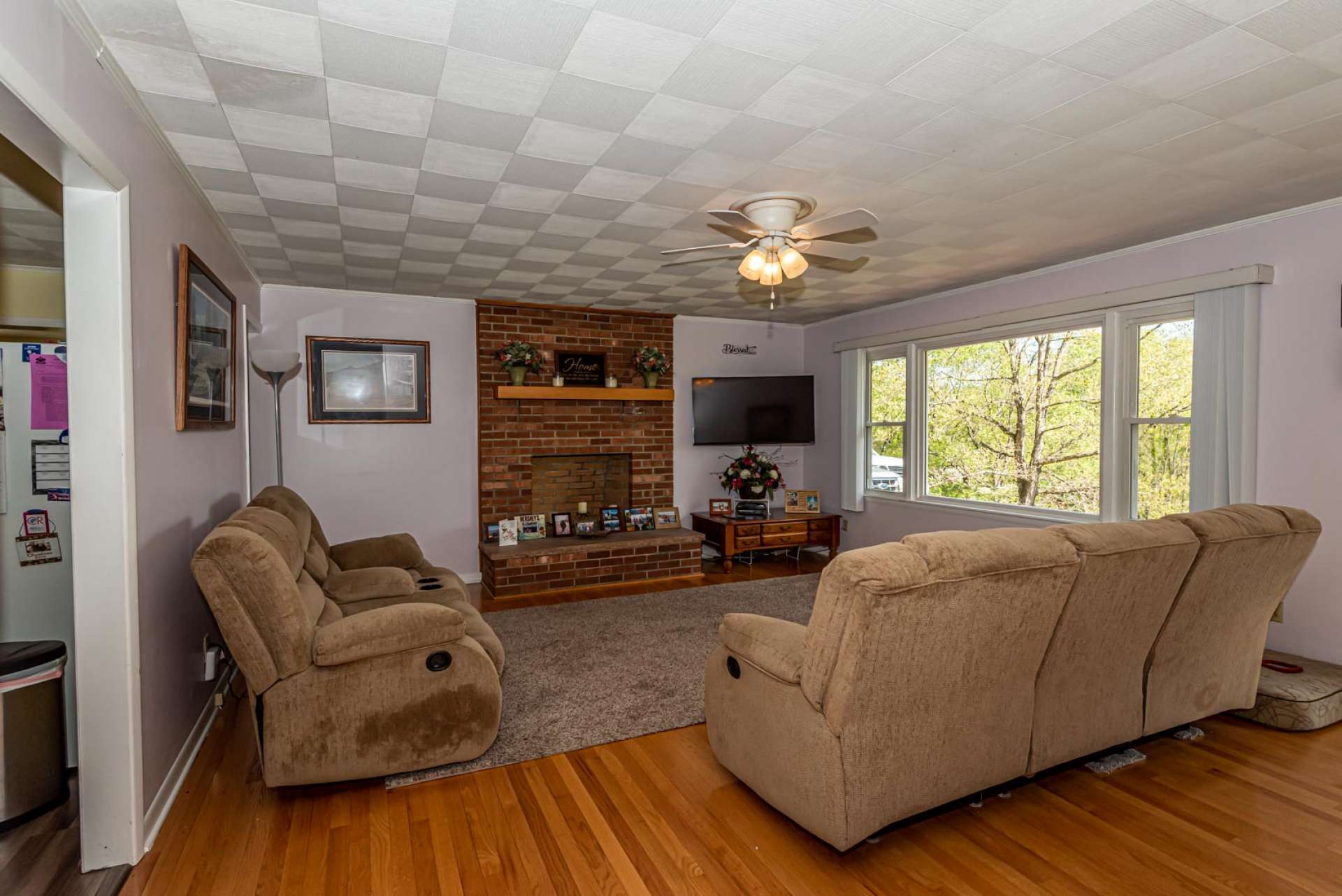 The living room features hardwood floor and large windows for natural light.