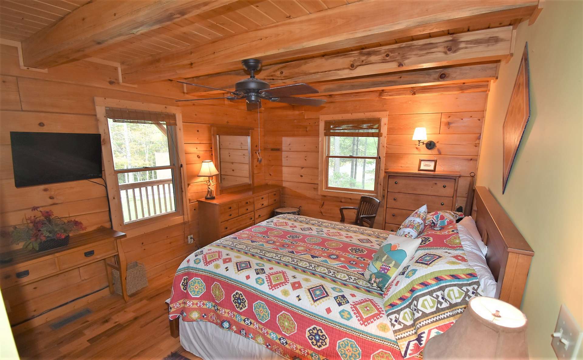 The main level master bedroom is spacious and features wood floor and exposed beams.