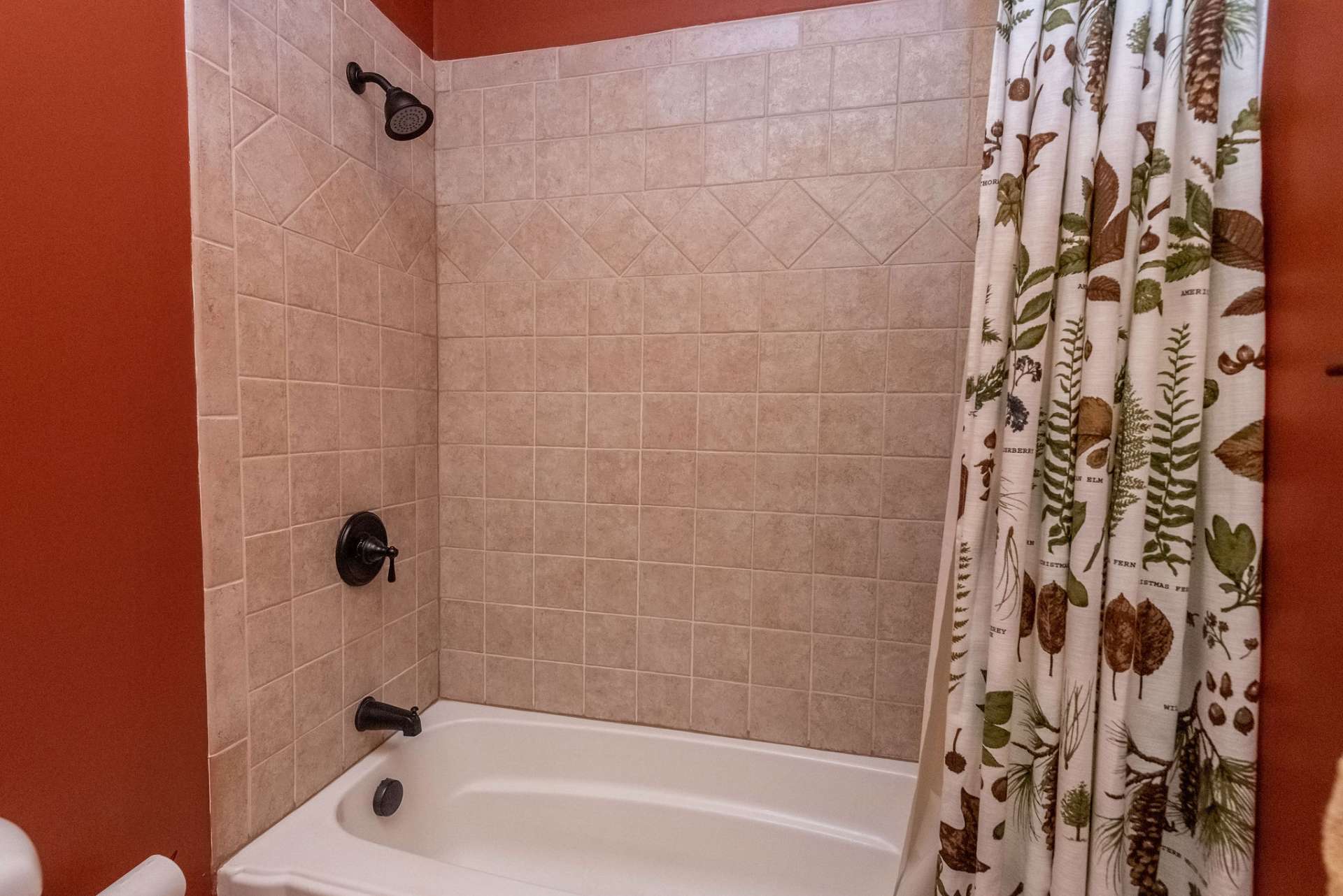 Upper level guest bath features a tile surround shower.