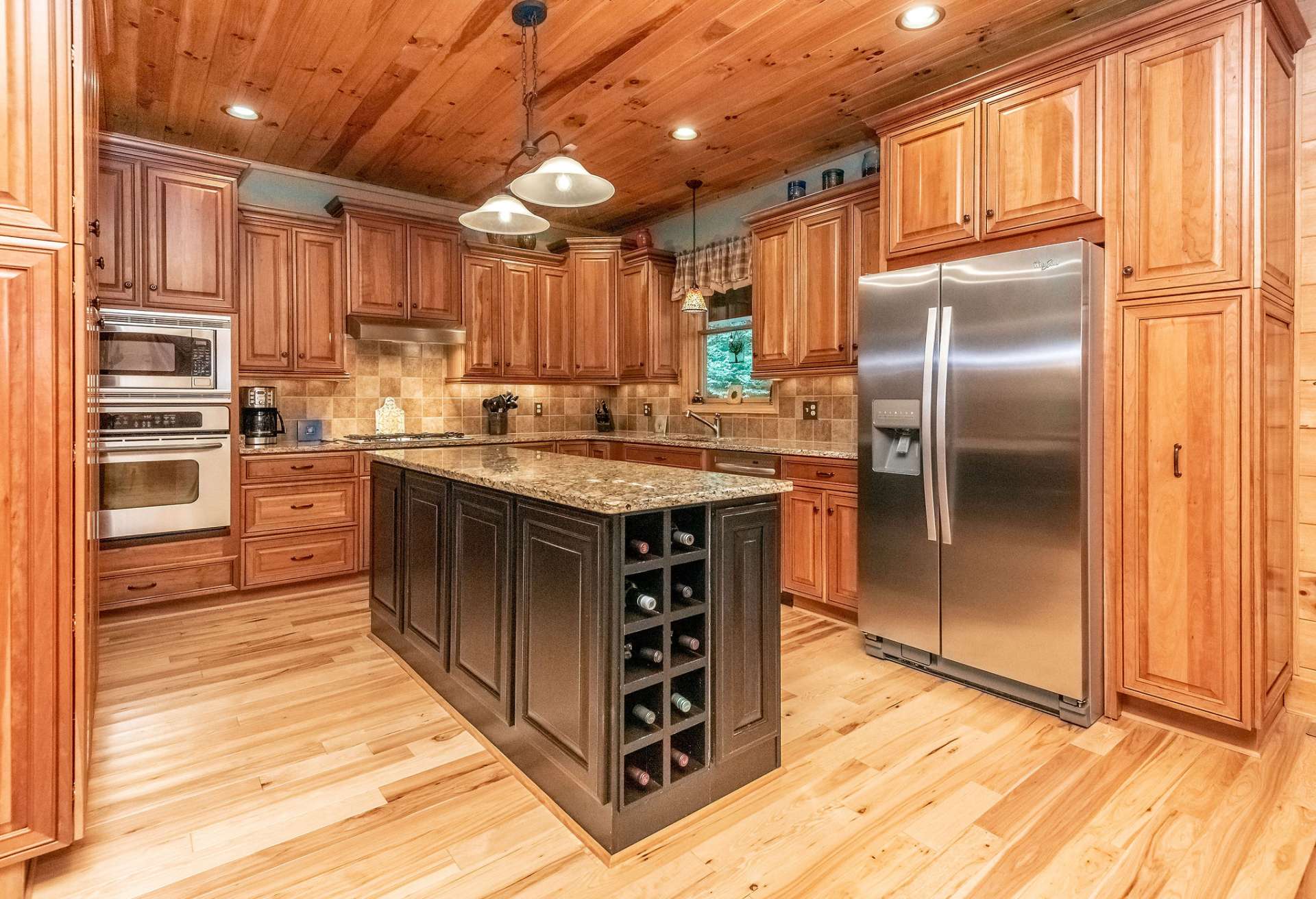 Kitchen features stainless appliances and beautiful wood cabinets with double pantries.