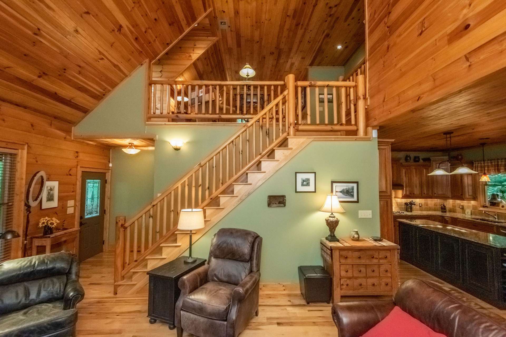 Vaulted ceilings open up to the loft area. Rustic railing leads the way.