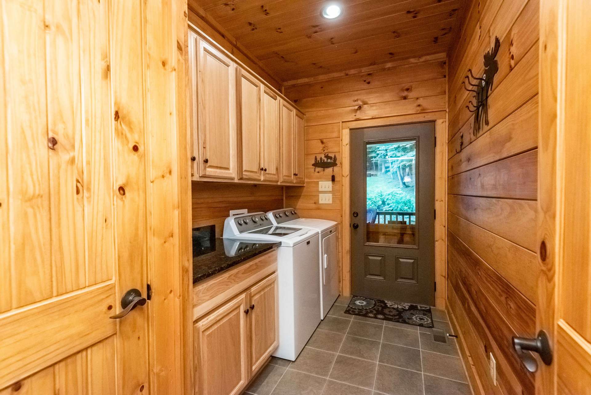 Come in from playing outside to this mud room equipped with extra storage, laundry, and tile flooring.