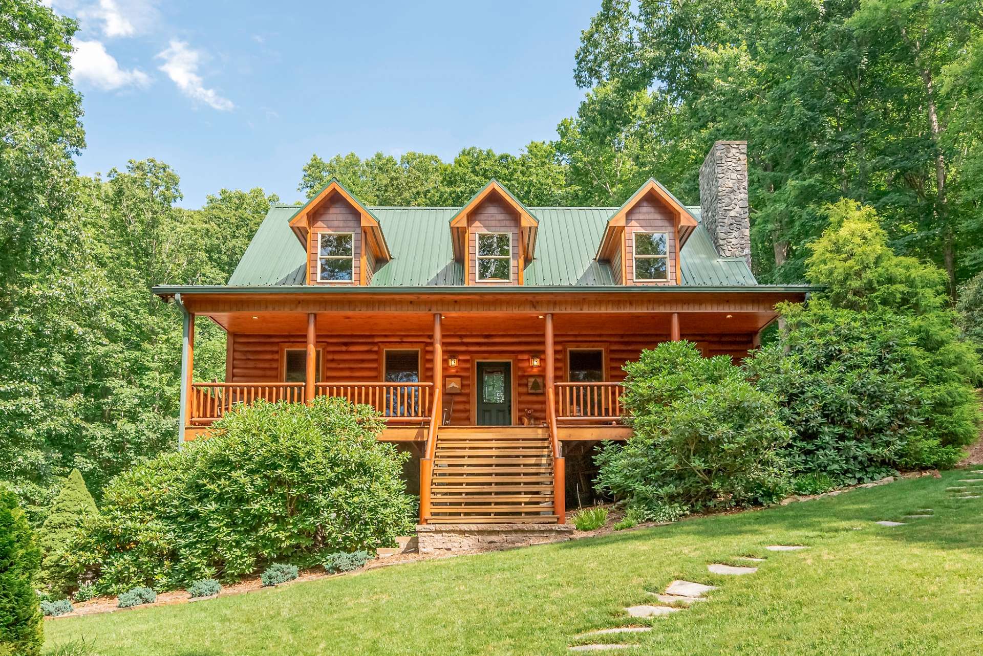 This majestic home glows with splendor and is nestled within the mature mountain foliage.