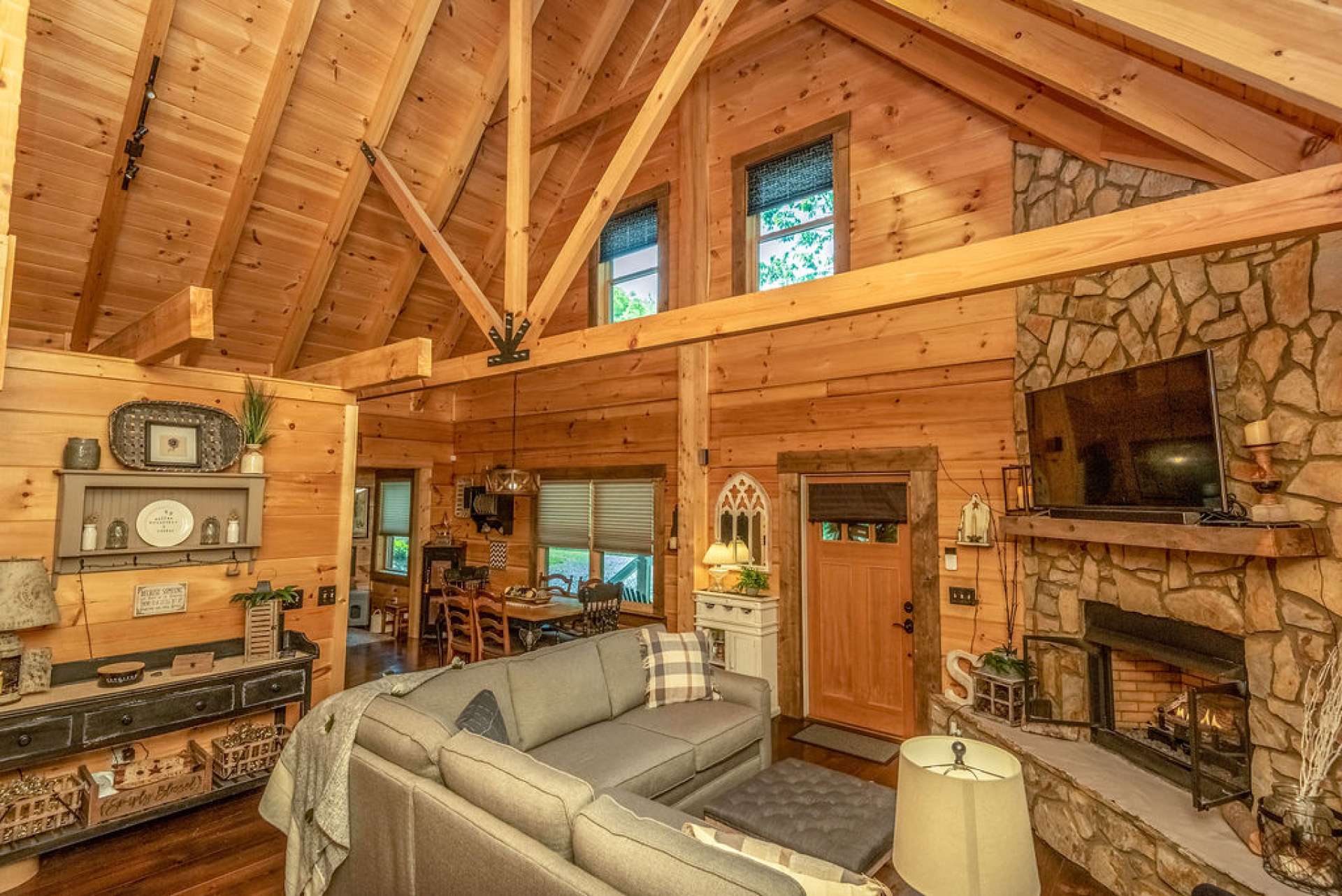 The great room offers a vaulted ceiling, wood floors, and stone fireplace with gas logs.