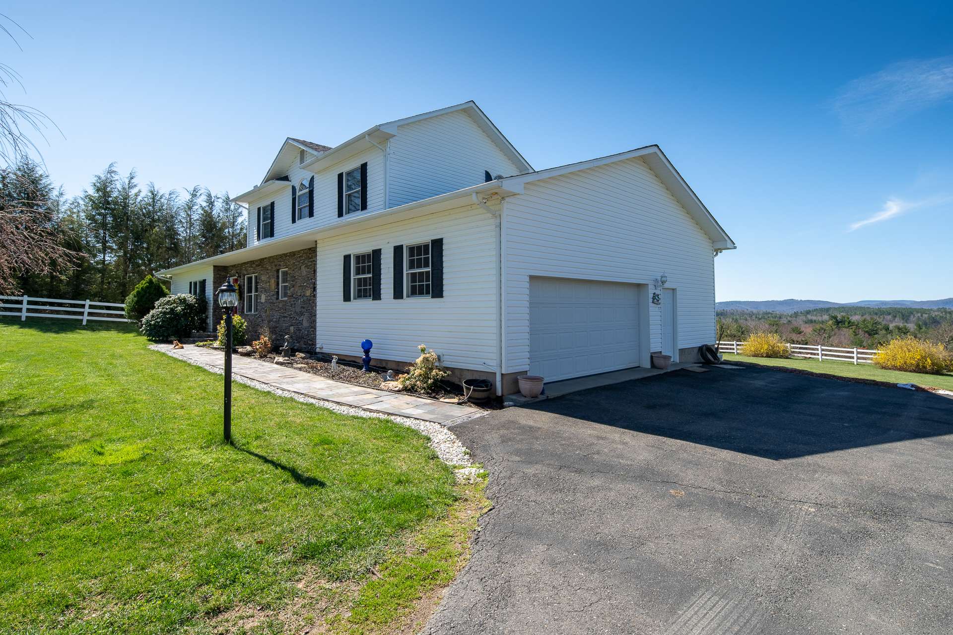 A paved driveway leads to an attached 2-car garage.