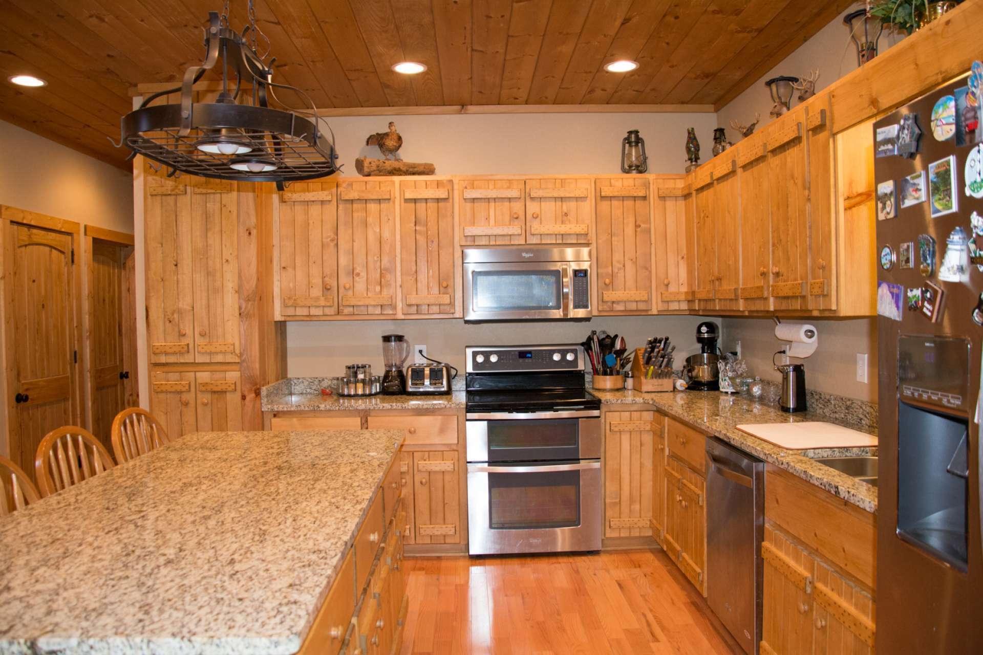 The beautiful kitchen offers custom cabinetry with granite counter tops, stainless appliances, large center work island and more than ample work and storage space.