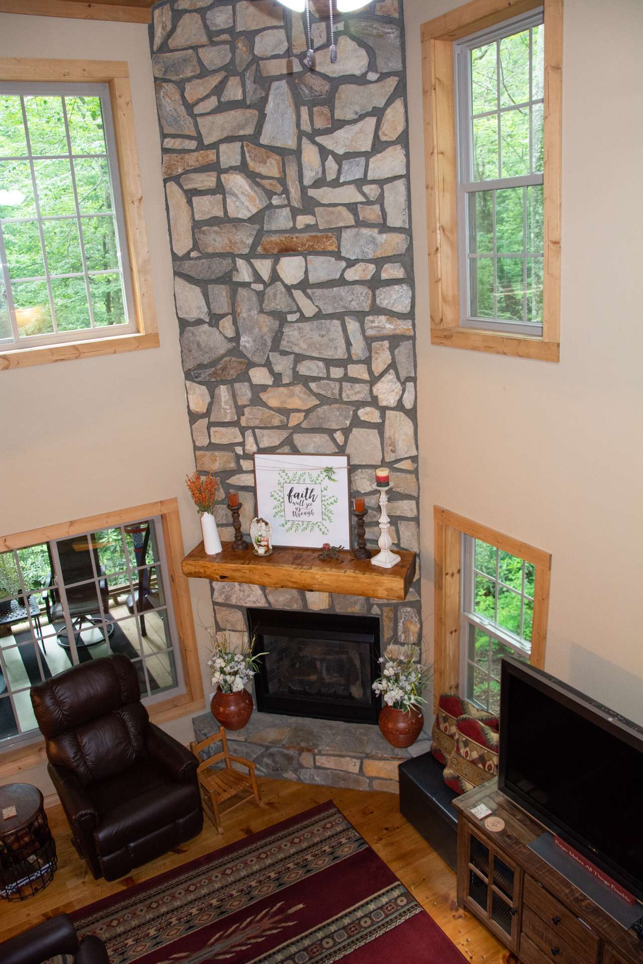 ...High vaulted ceiling with lots of windows for natural light, and a stone fireplace with gas logs for those chilly evenings in the mountains.