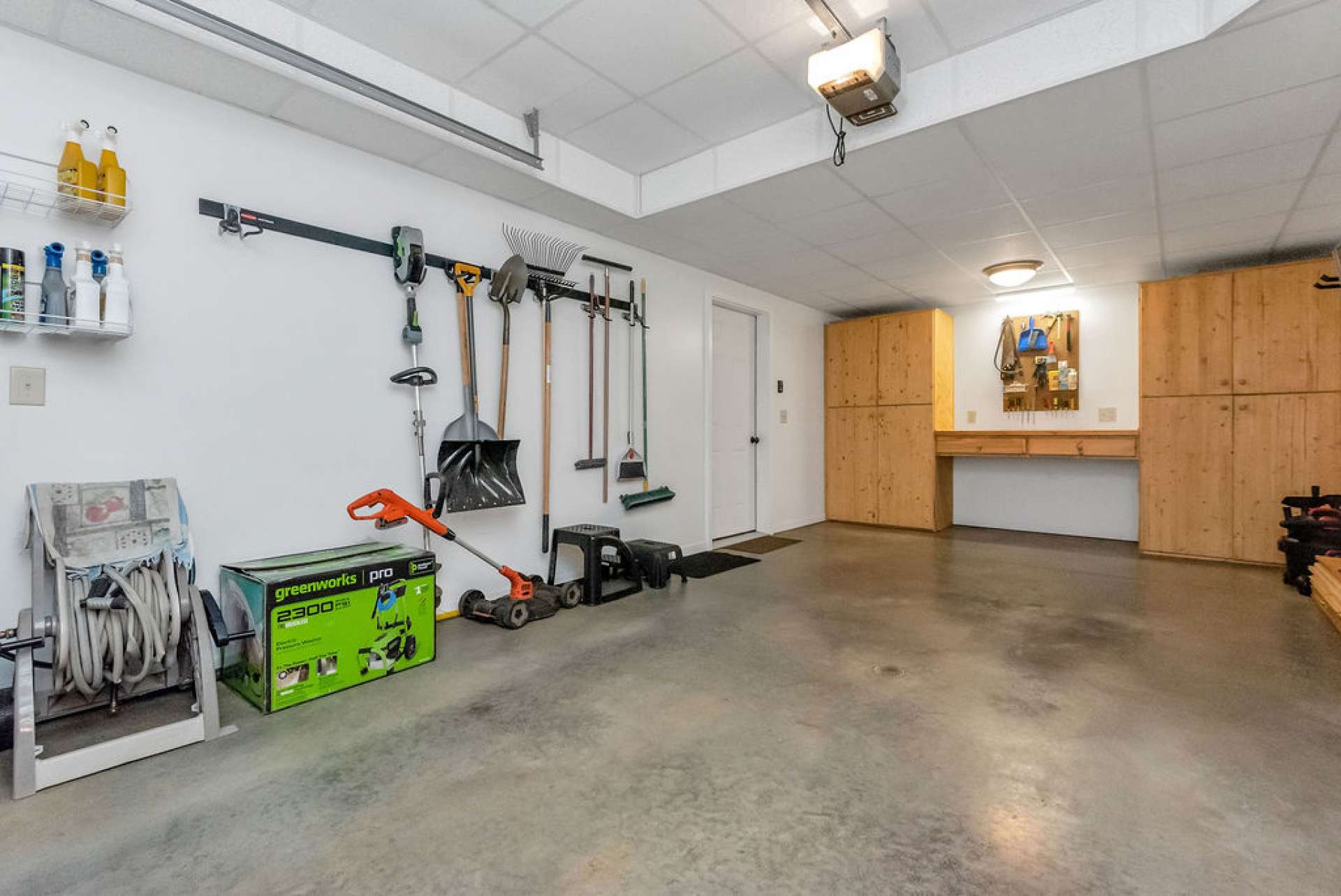 One car garage offers a work area and extra storage.