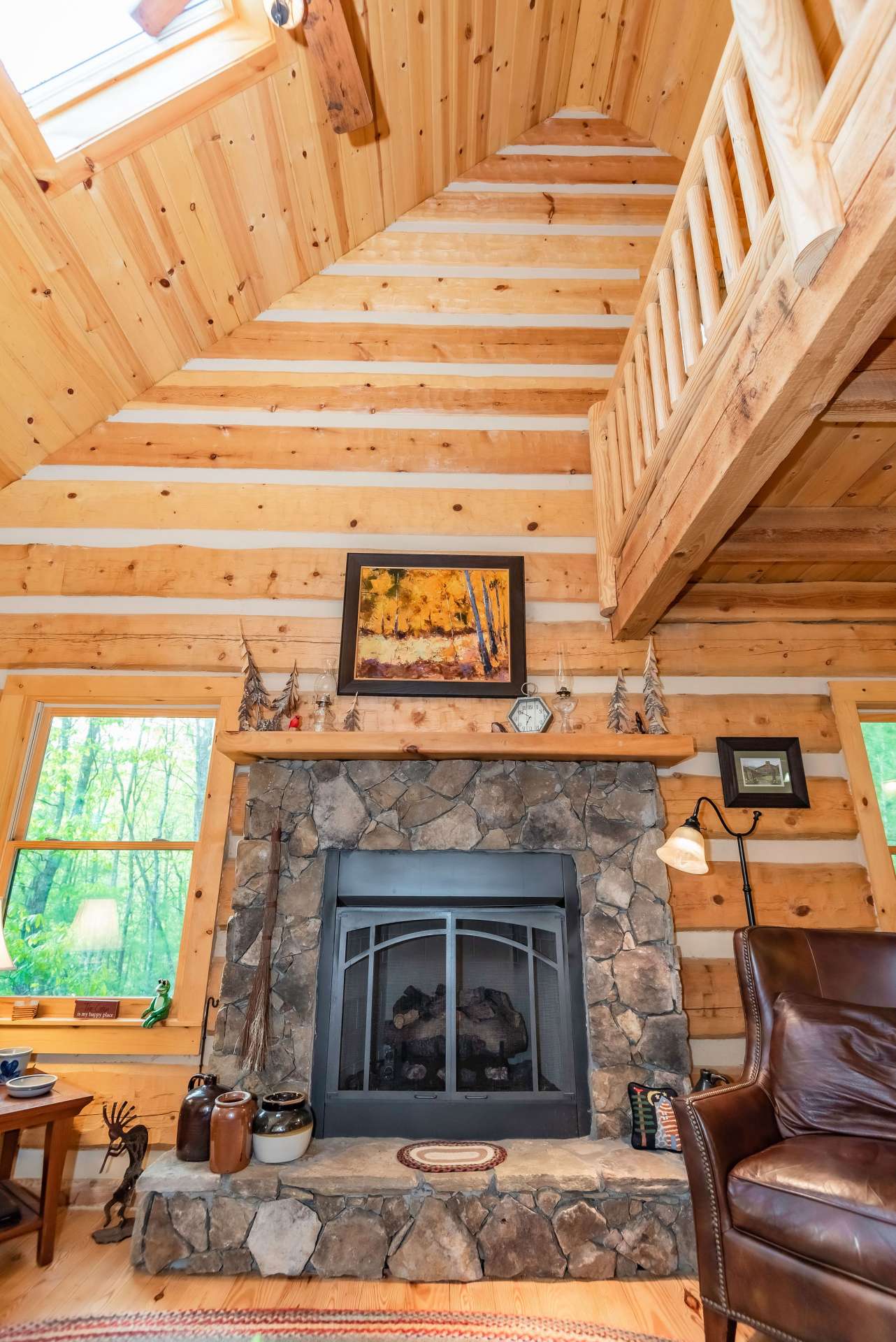 The fireplace is the focal point of the living area.  Notice the skylight allowing more natural light inside the cabin.