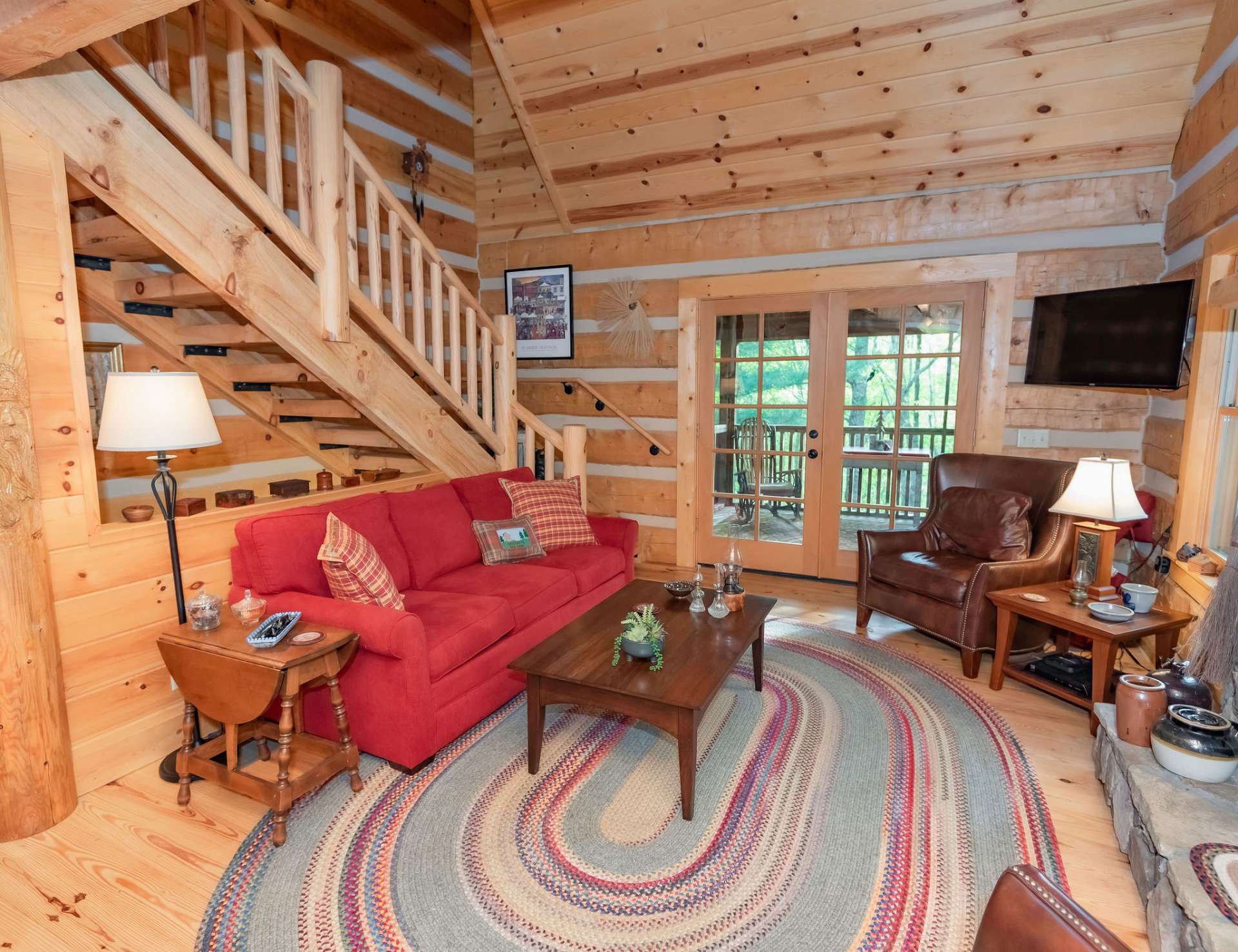 A vaulted great room is filled with natural light and features wood floors and a fireplace with gas logs.