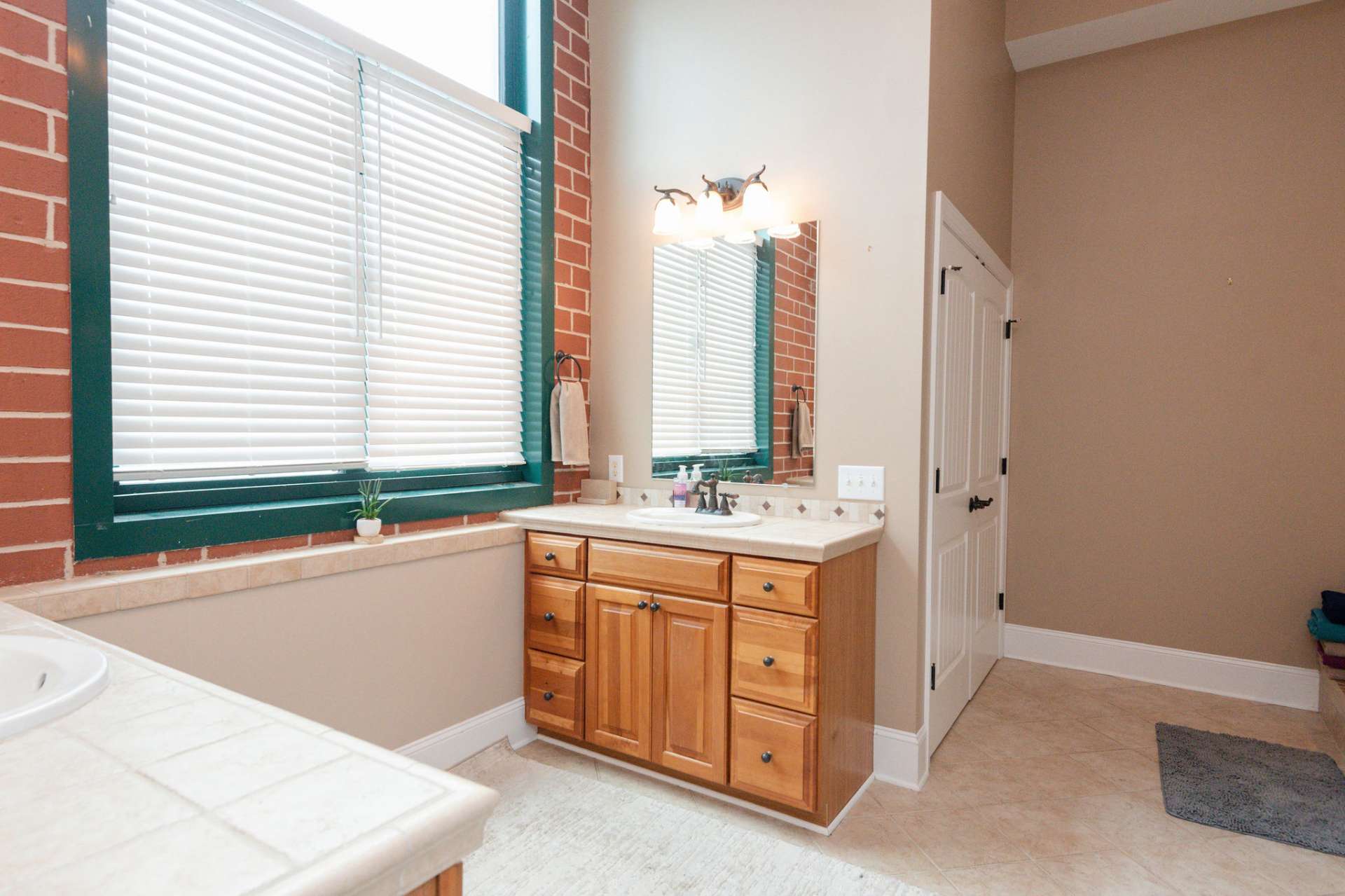 Large window in the master bath lets the natural light in at the twin vanities.