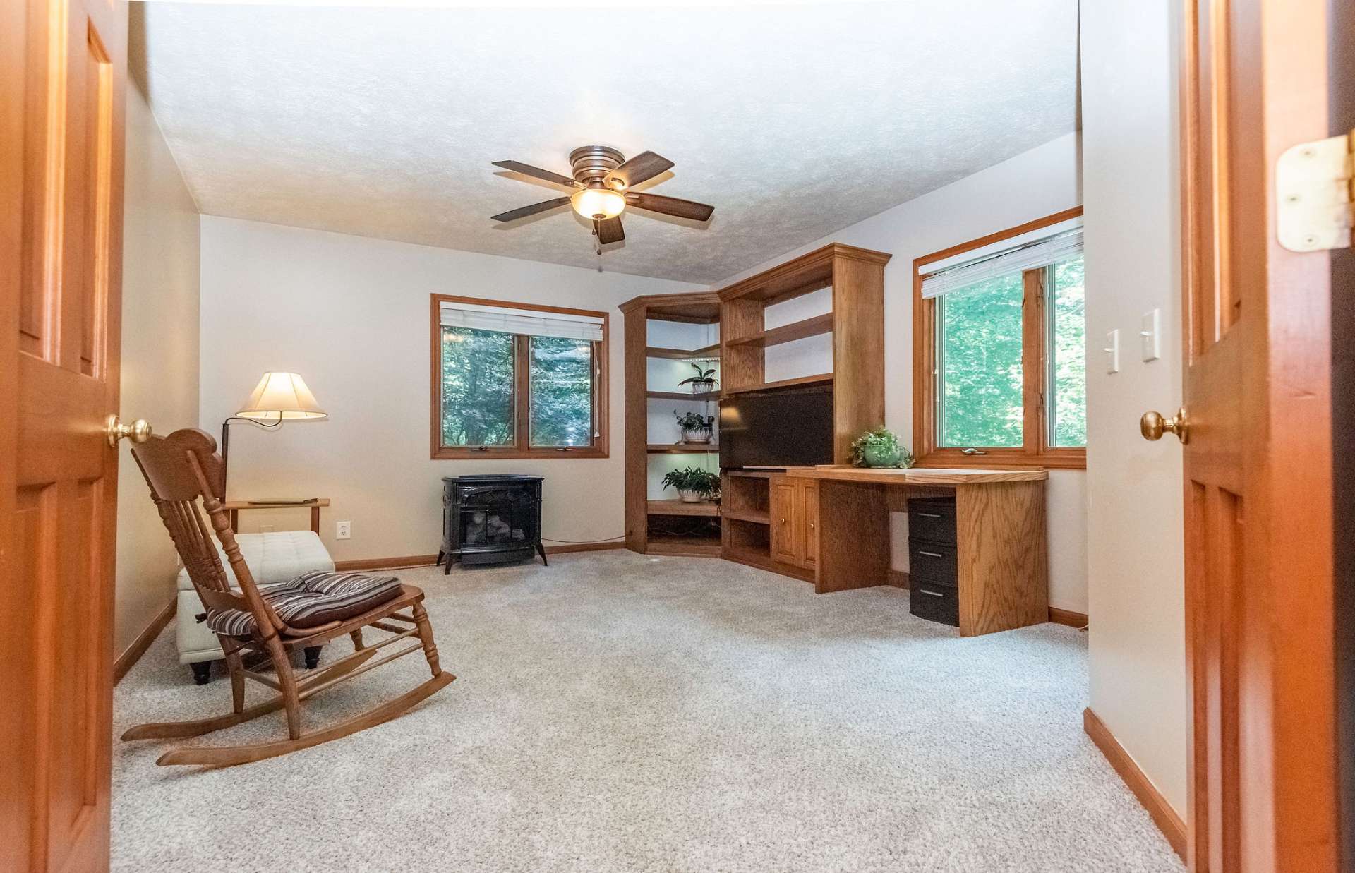 This room on main level could serve as an office, den, or bedroom. Previously used as a bedroom, and current owner's used as a den. Windows were added where the desk is located at the same time as french door and deck in master suite.