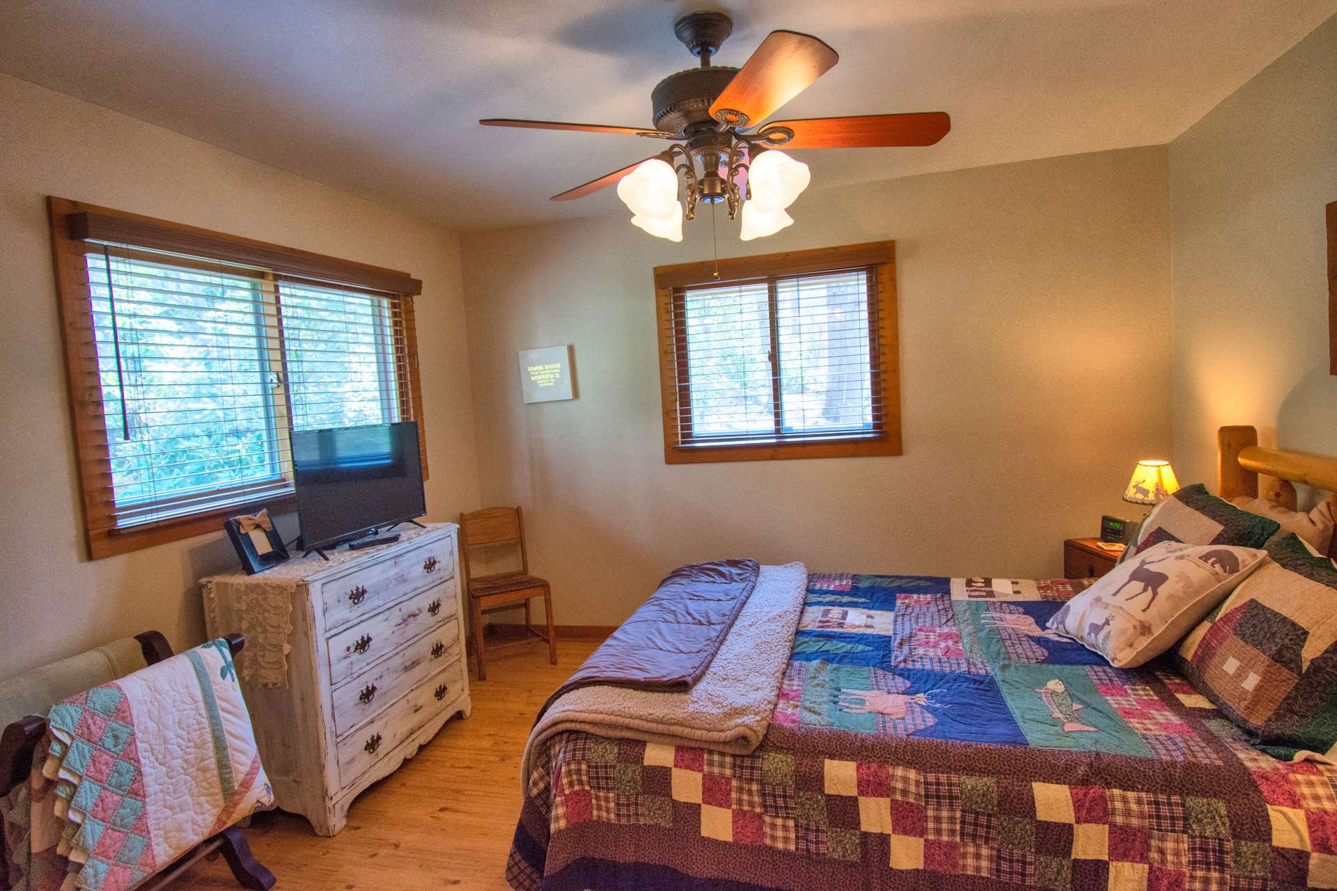 The bedroom is both spacious and cozy with lots of windows for natural light.