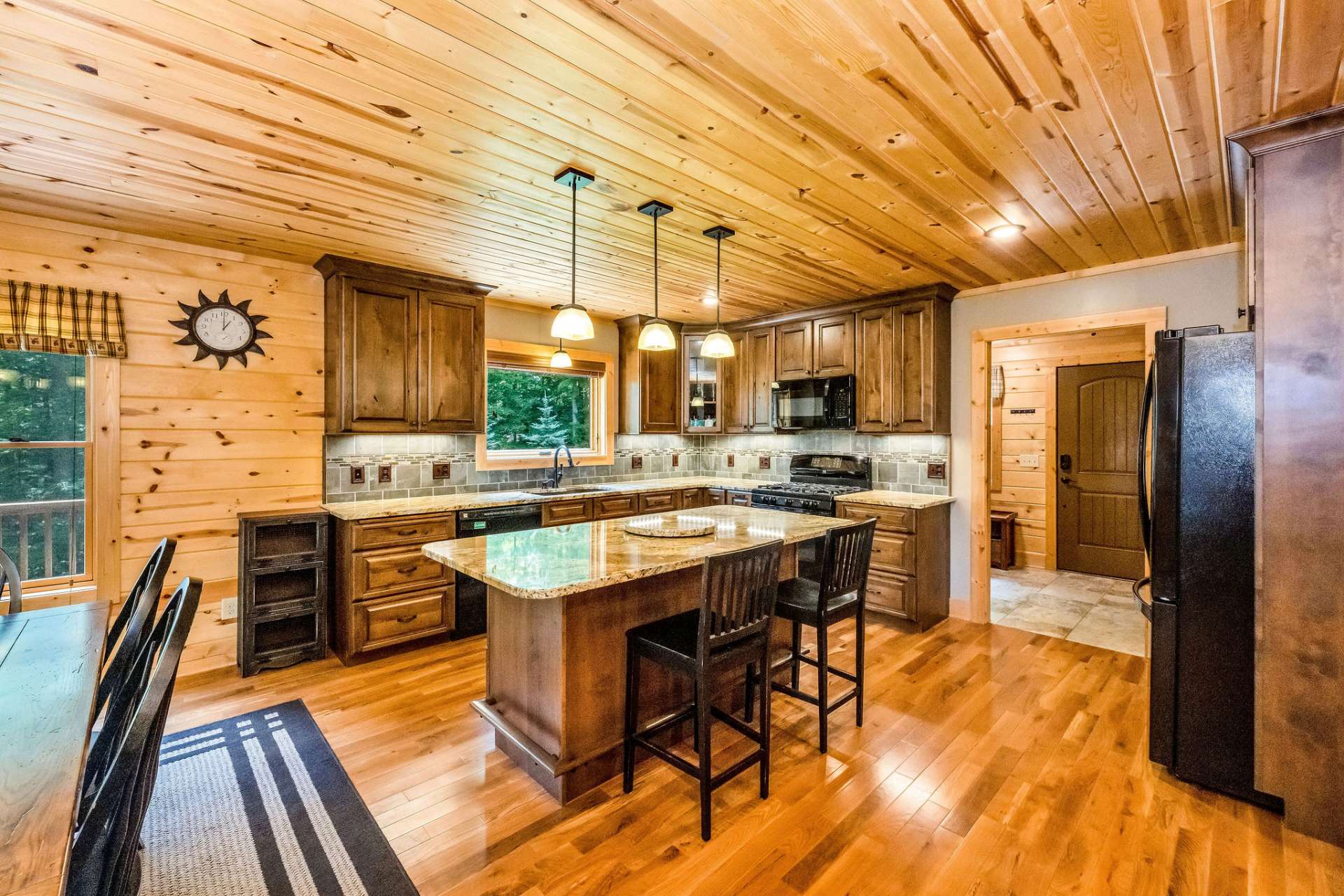 An oversized island anchors the space, offering additional prep space, casual seating, and seamless connection to the dining and living areas.