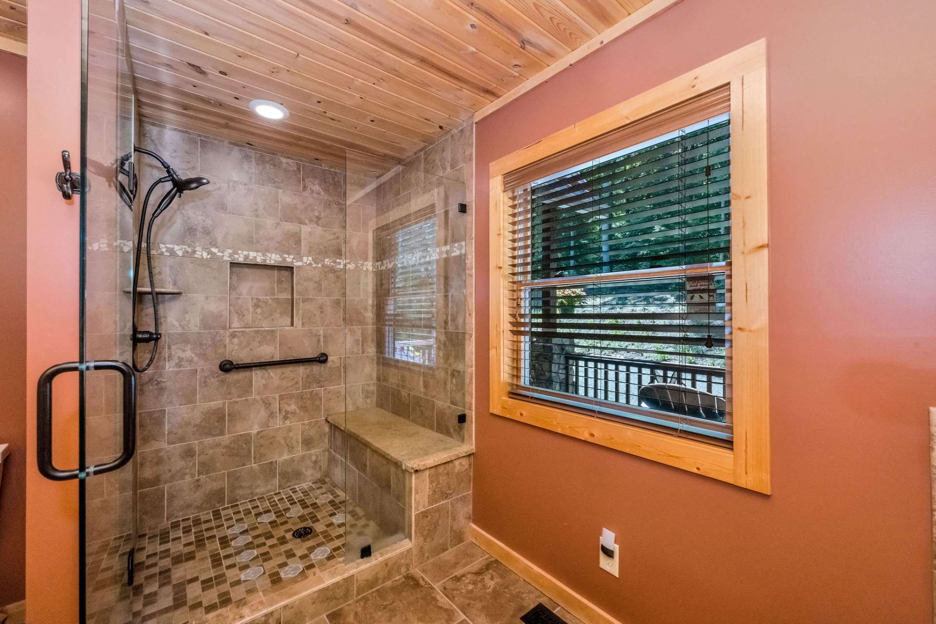 A beautifully tiled shower with bench seating blends luxury with everyday ease.