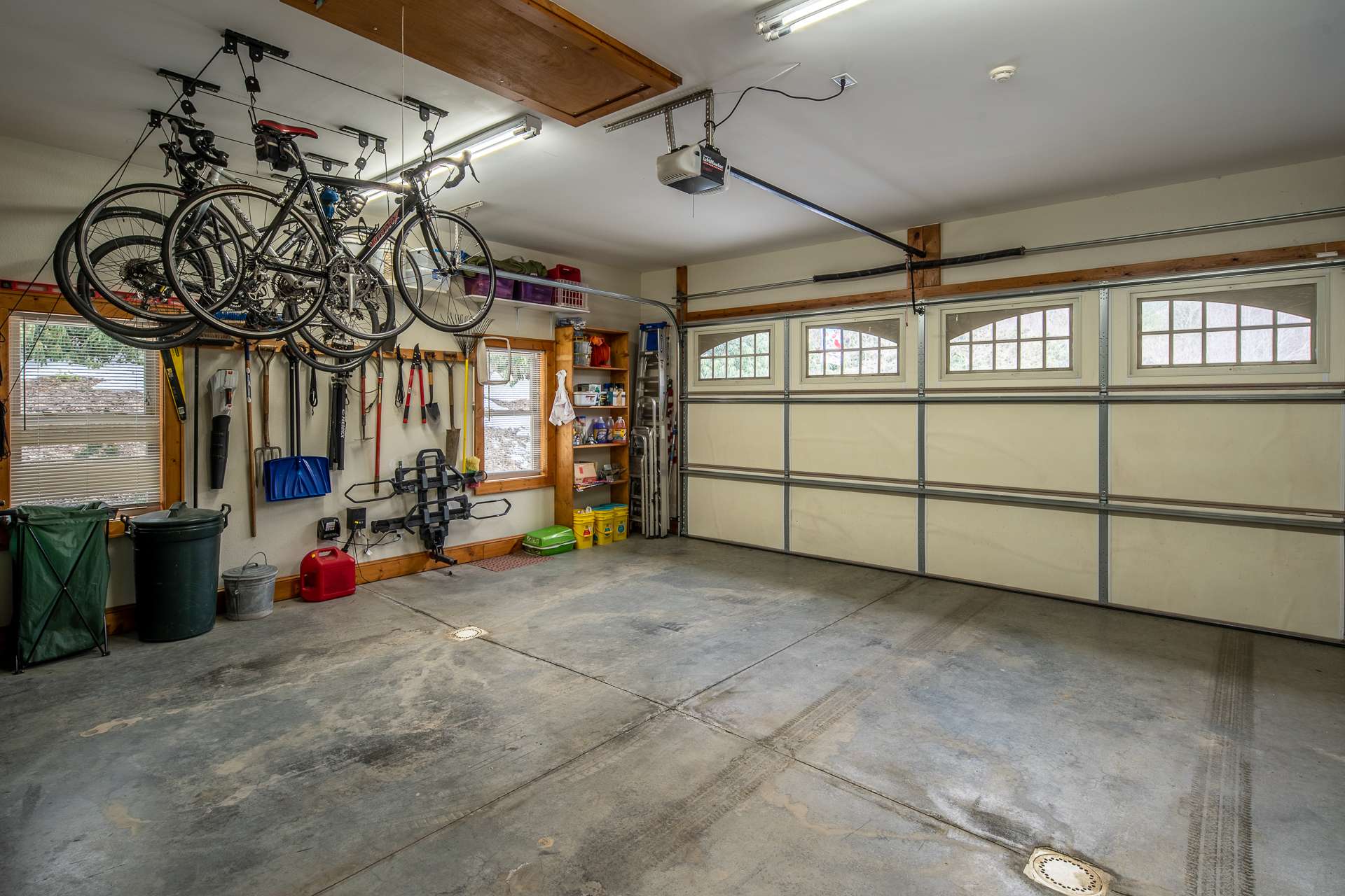 The oversized 2-car main level garage features double door access with no squeezing vehicles between pillars.  Garage also offers pull down steps to access a storage area overhead, a utility sink and exterior door to wood storage area behind house.