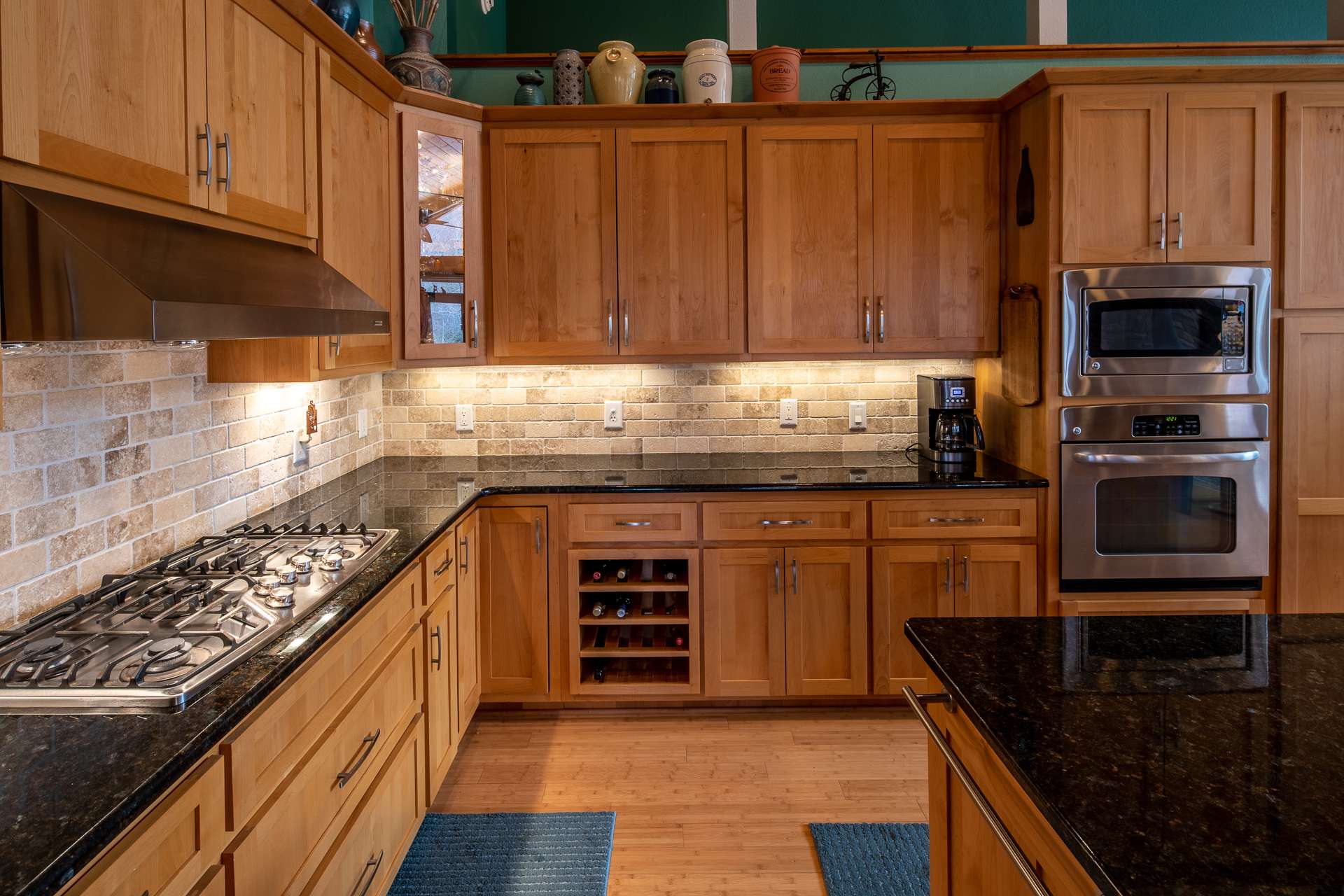 Well-appointed kitchen offers abundant storage and counter space, granite counter tops, stainless steel appliances including a 5-burner gas cooktop.