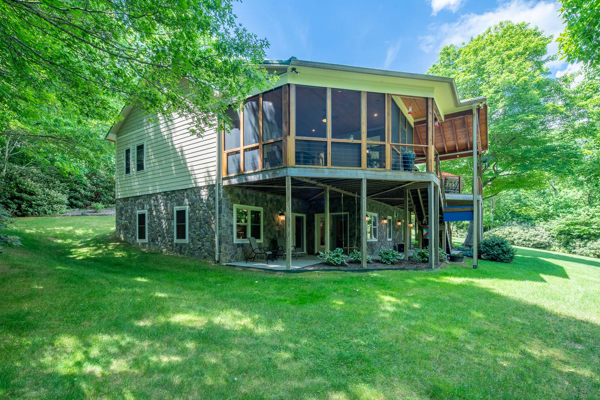 In addition to wrap-around porch, outdoor living space includes lower level patio with access from inside or outside.