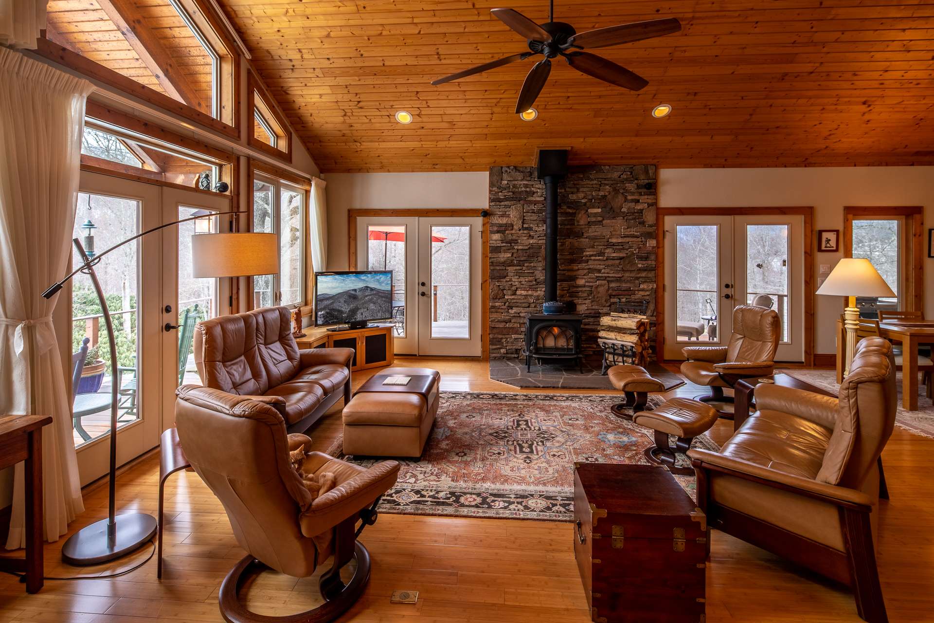 Features include vaulted T&G ceiling, bamboo flooring and efficient Jotul wood stove accented by stacked stone wall.