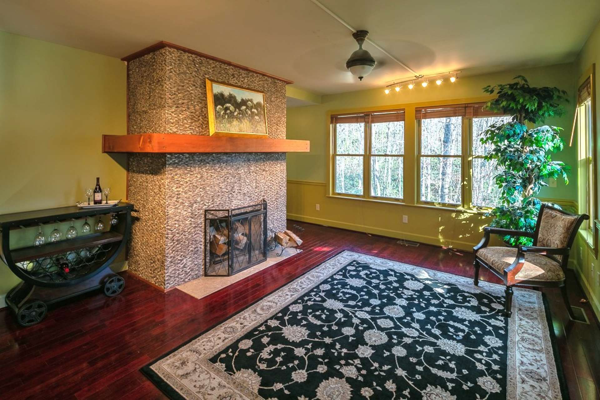 The main level welcomes you with a light and airy ambiance and features an open concept floor plan.  The living area features lots of windows, beautiful wood floor, and a striking wood-burning fireplace with stone surround.