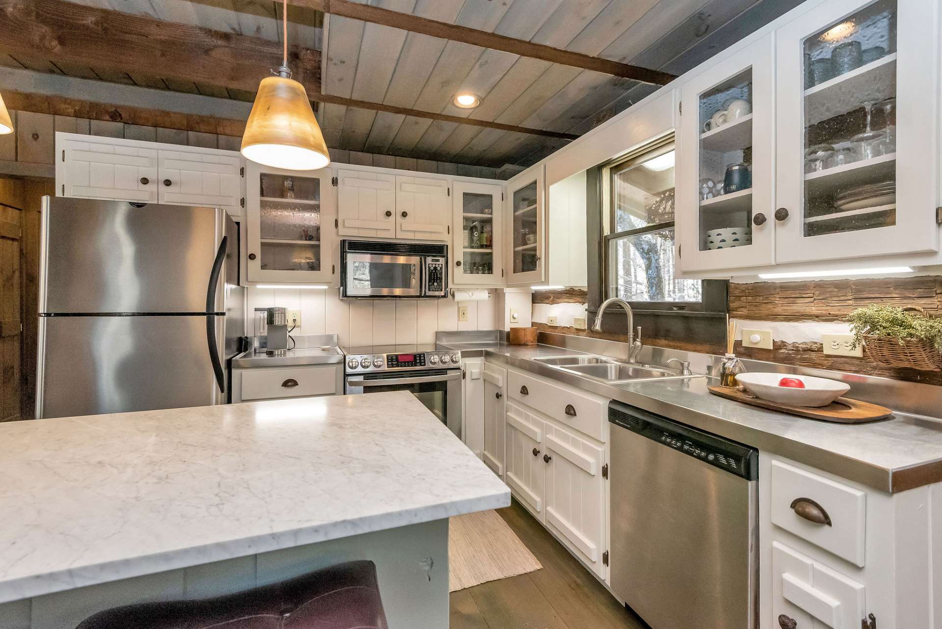 One of the standout features of the kitchen is its unique stainless steel countertops. The sleek, industrial-inspired surface provides a striking contrast to the warmth of the cabin's rustic elements, adding a touch of contemporary flair to the space.