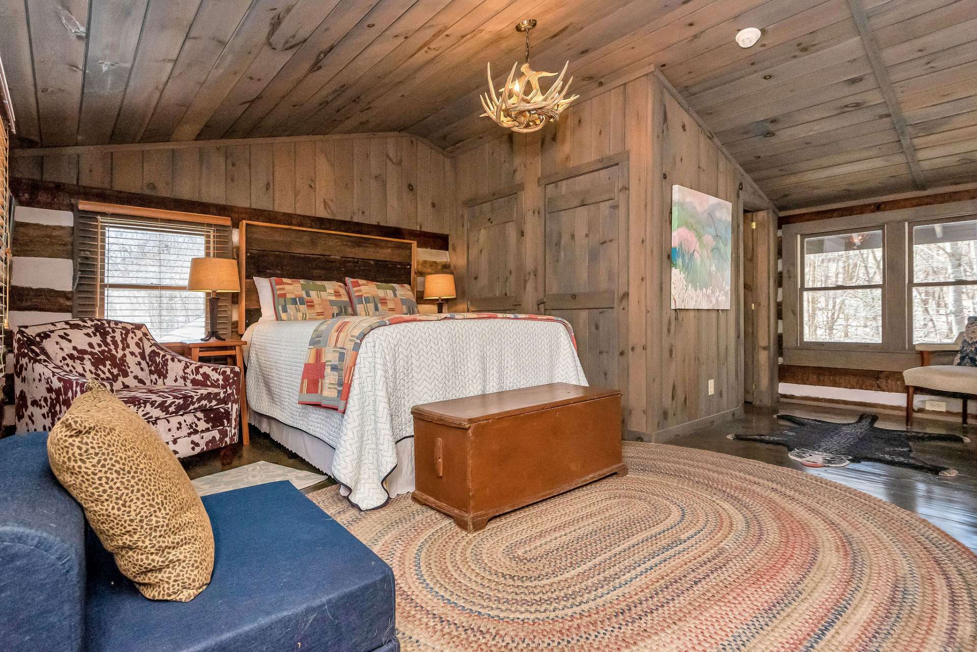 The open loft bedroom is a picturesque retreat that combines spaciousness with rustic charm, offering a cozy haven nestled beneath the vaulted ceiling. Its generous proportions allow for the inclusion of a cozy sitting area.