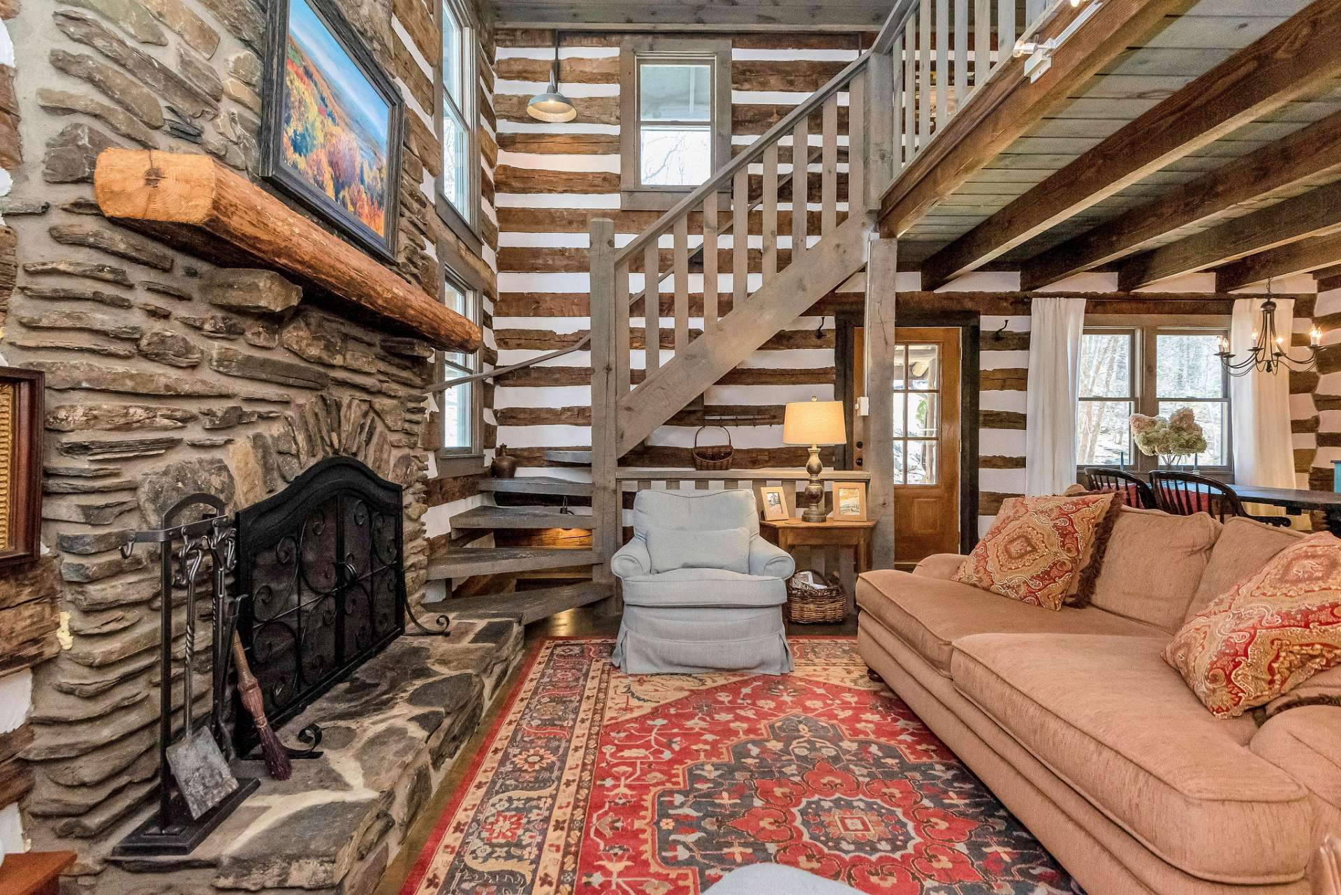 A rustic stairway crafted from natural wood leads to the open loft above, adding an element of whimsy and adventure to the space.