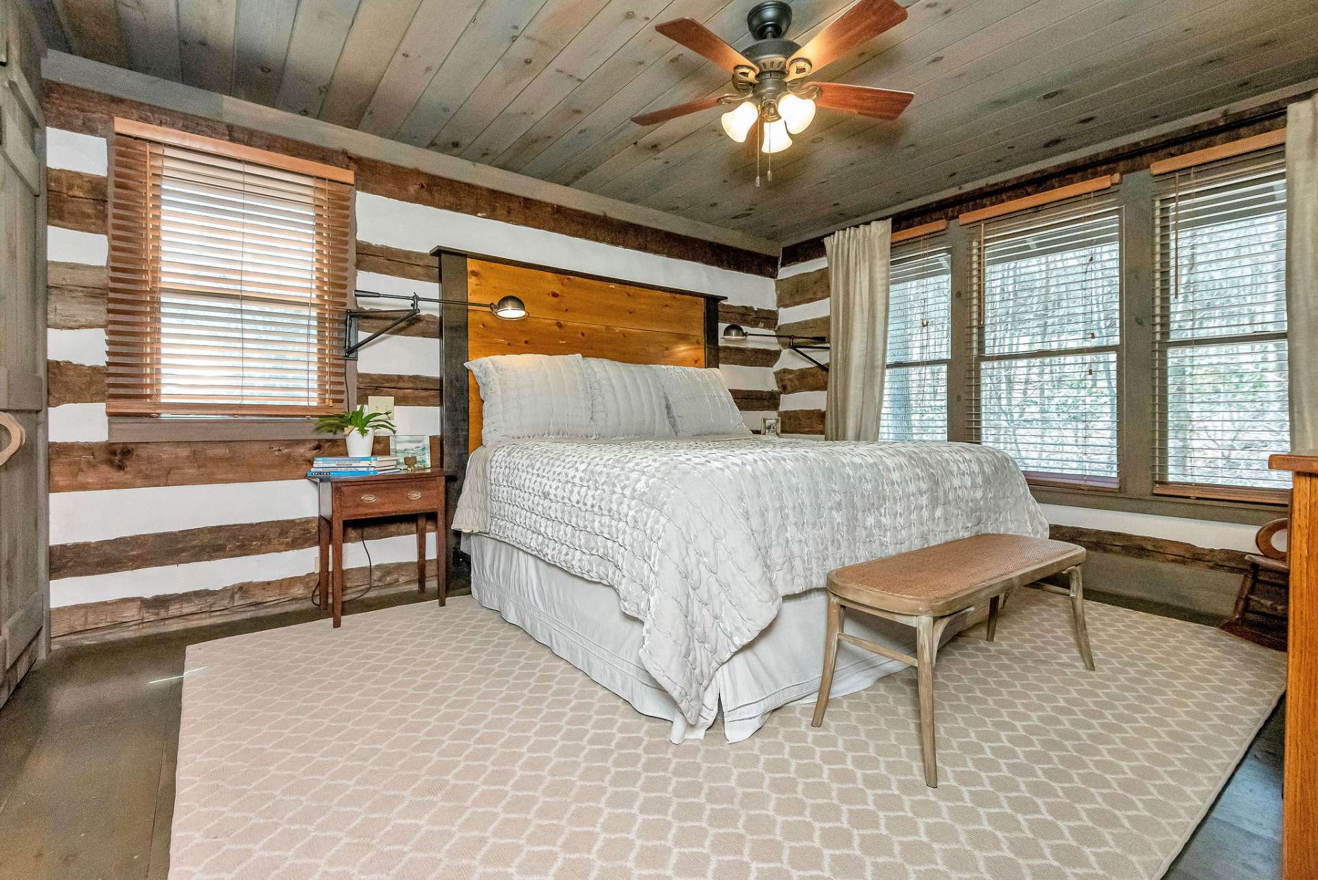 Located on the main level of the cabin, the primary bedroom provides easy access and convenience for the occupants, offering a sense of privacy and tranquility away from the main living areas.