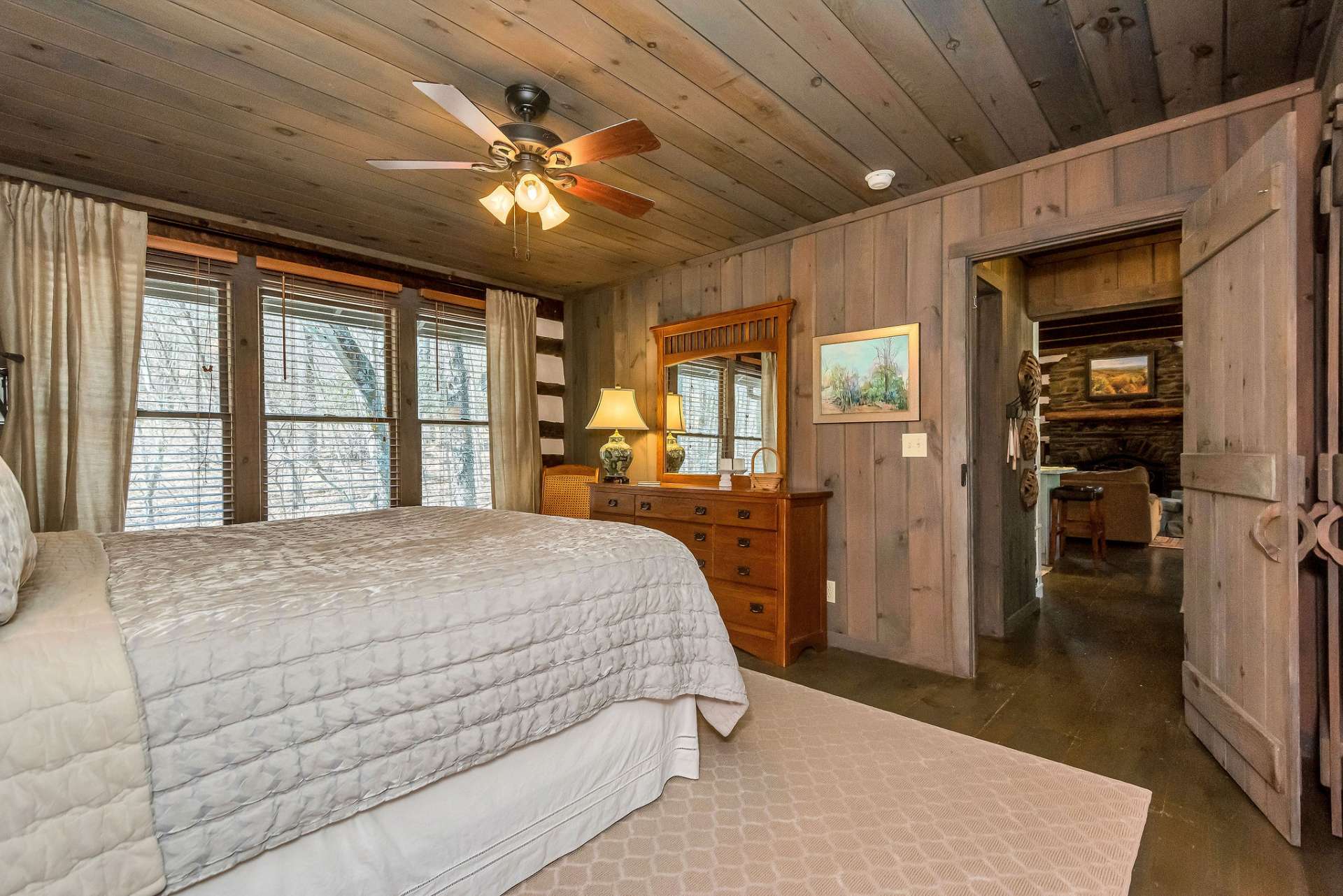 With its proximity to the noisy mountain stream behind the cabin, the bedroom provides a tranquil soundtrack of flowing water, creating a soothing ambiance that promotes restful sleep and relaxation.