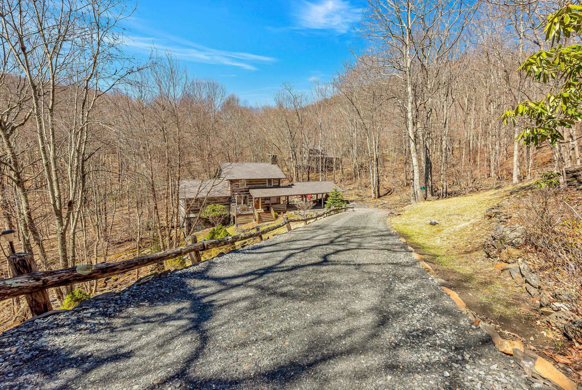 Private driveway leads down to the cabin set against a backdrop of serene natural beauty and a noisy mountain stream.