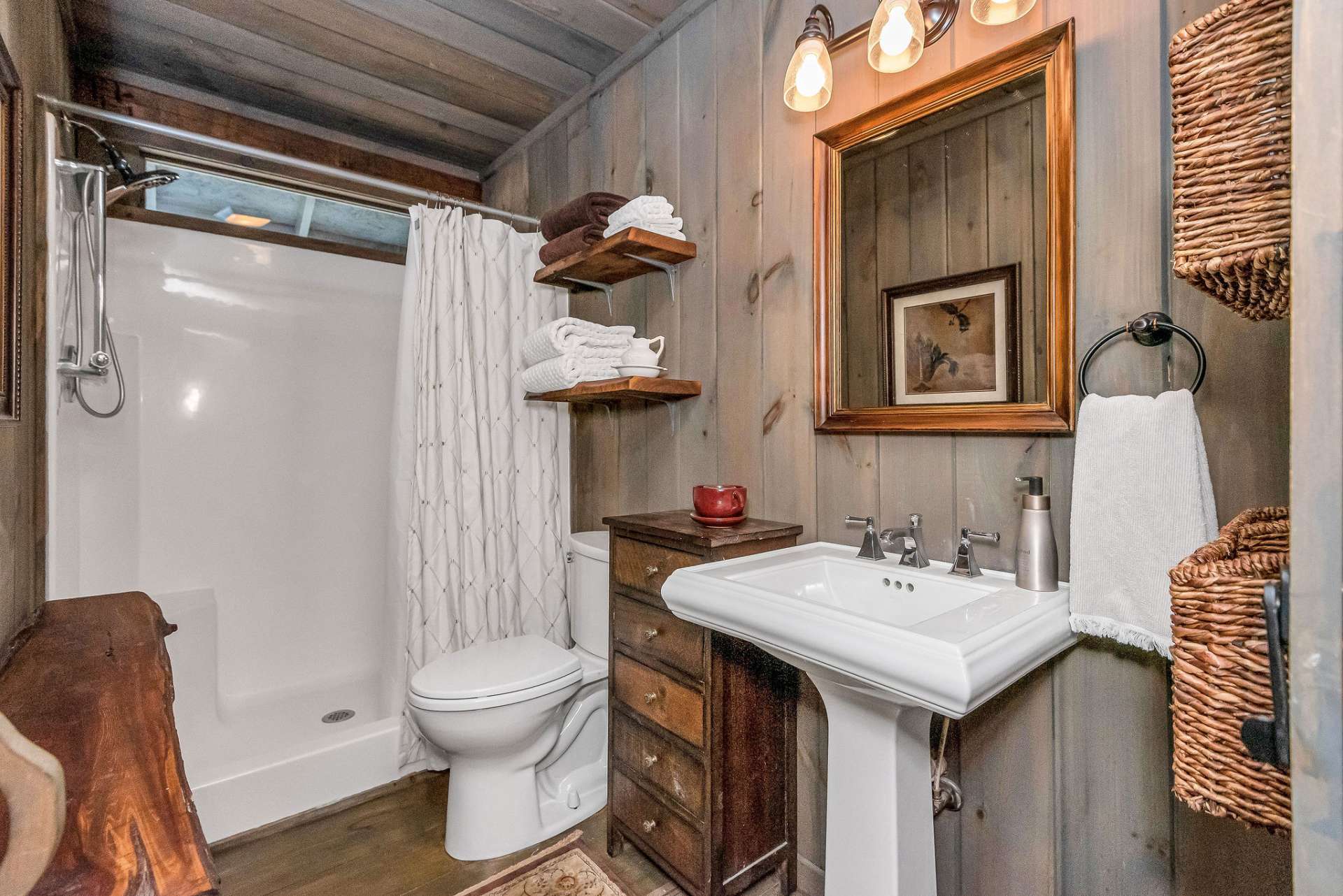 The main level bathroom offers a shower with two seats and a pedestal sink which adds a touch of vintage charm.