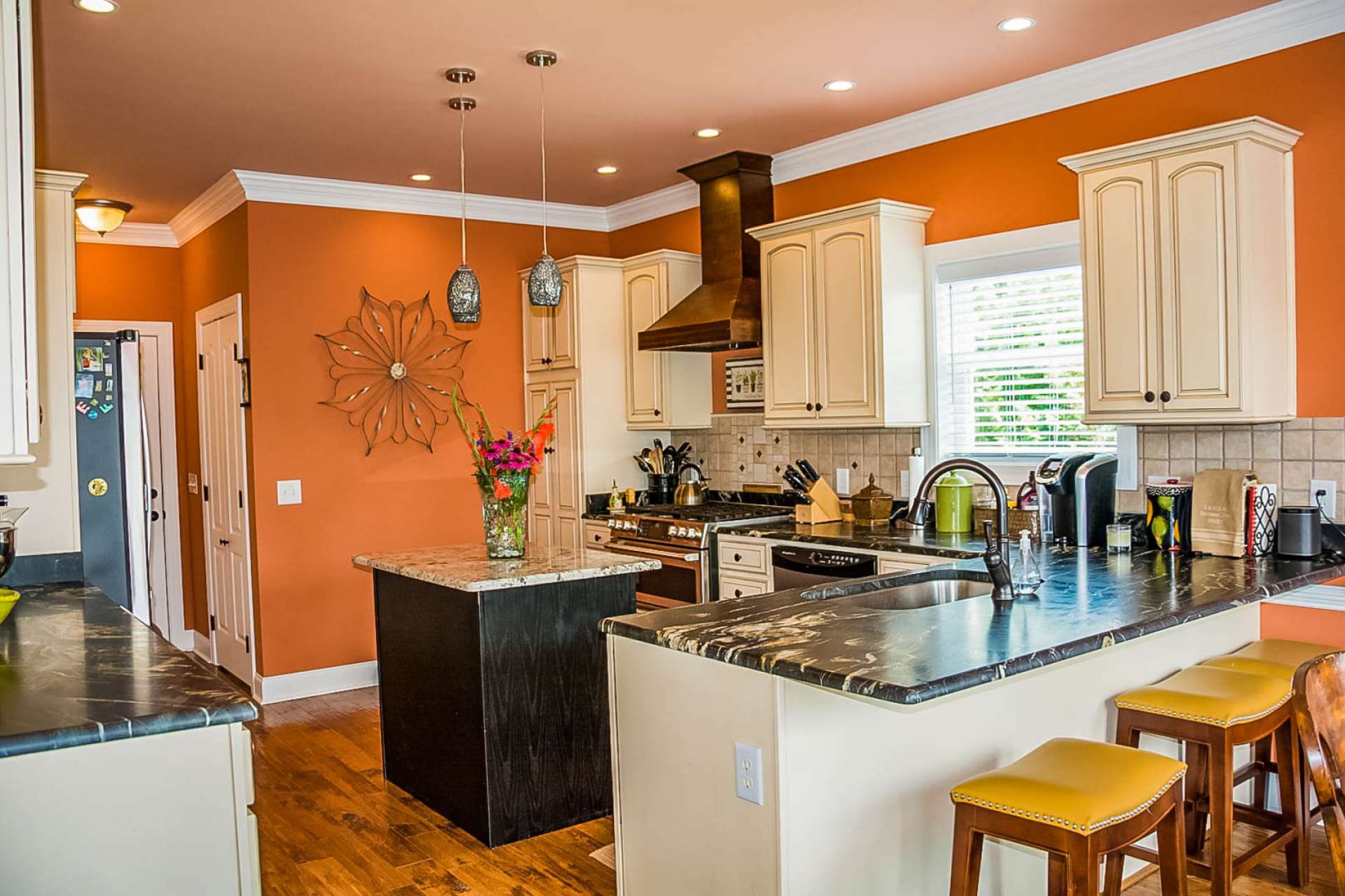This beautifully renovated kitchen offers abundant cabinetry, unique granite, stainless appliances, walk-in pantry, and plenty of work and storage space that includes a bar with seating.