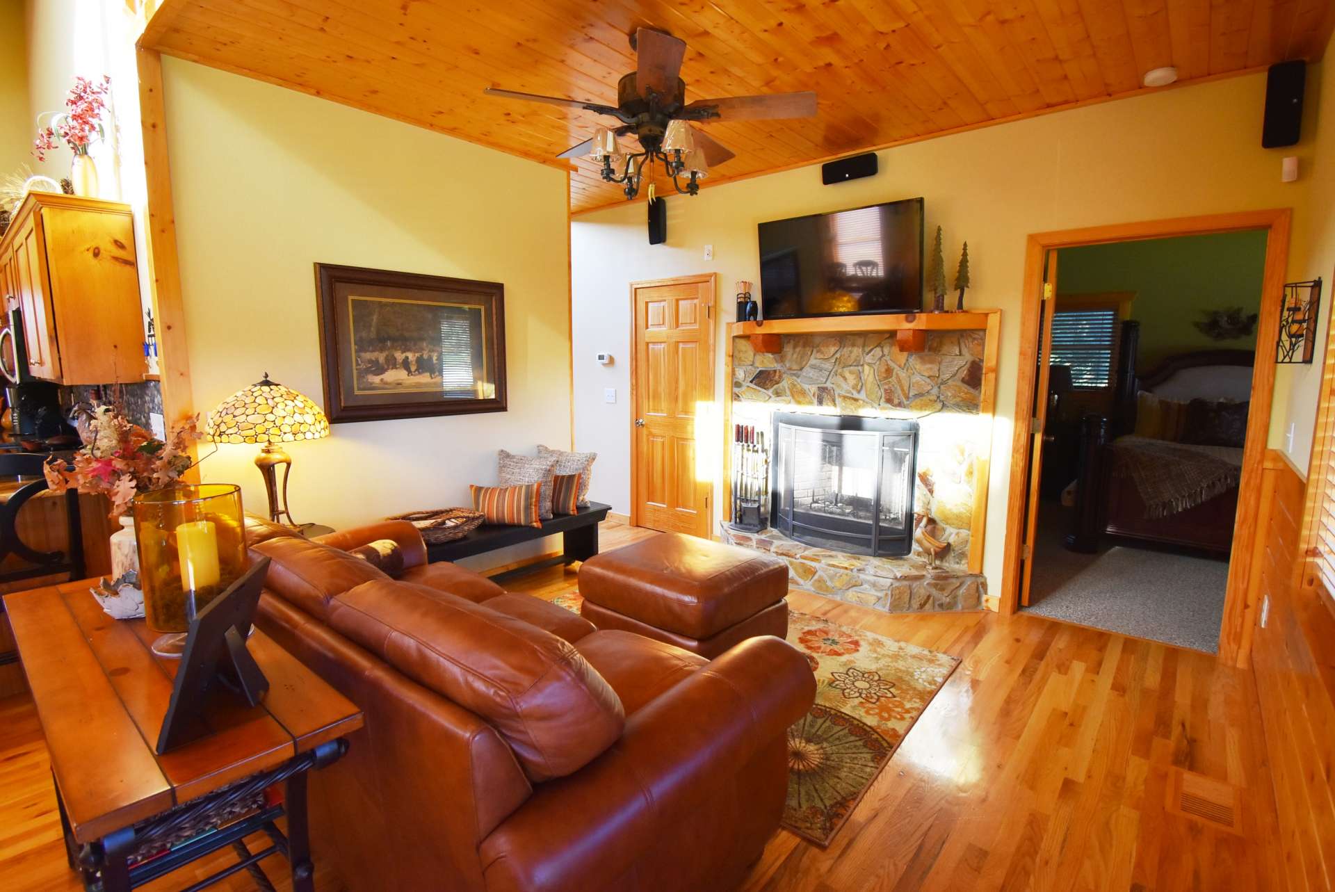 The bright vaulted great room offers gleaming wood floors, and a wood-burning fireplace for added warmth on winter evenings.