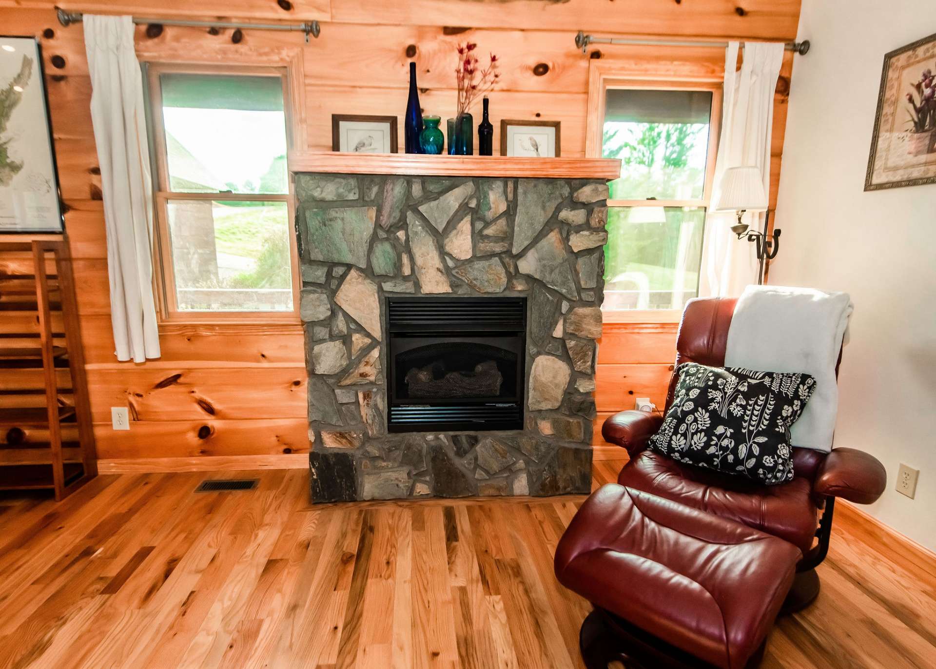 The living area features a  gas log fireplace and wood floors.