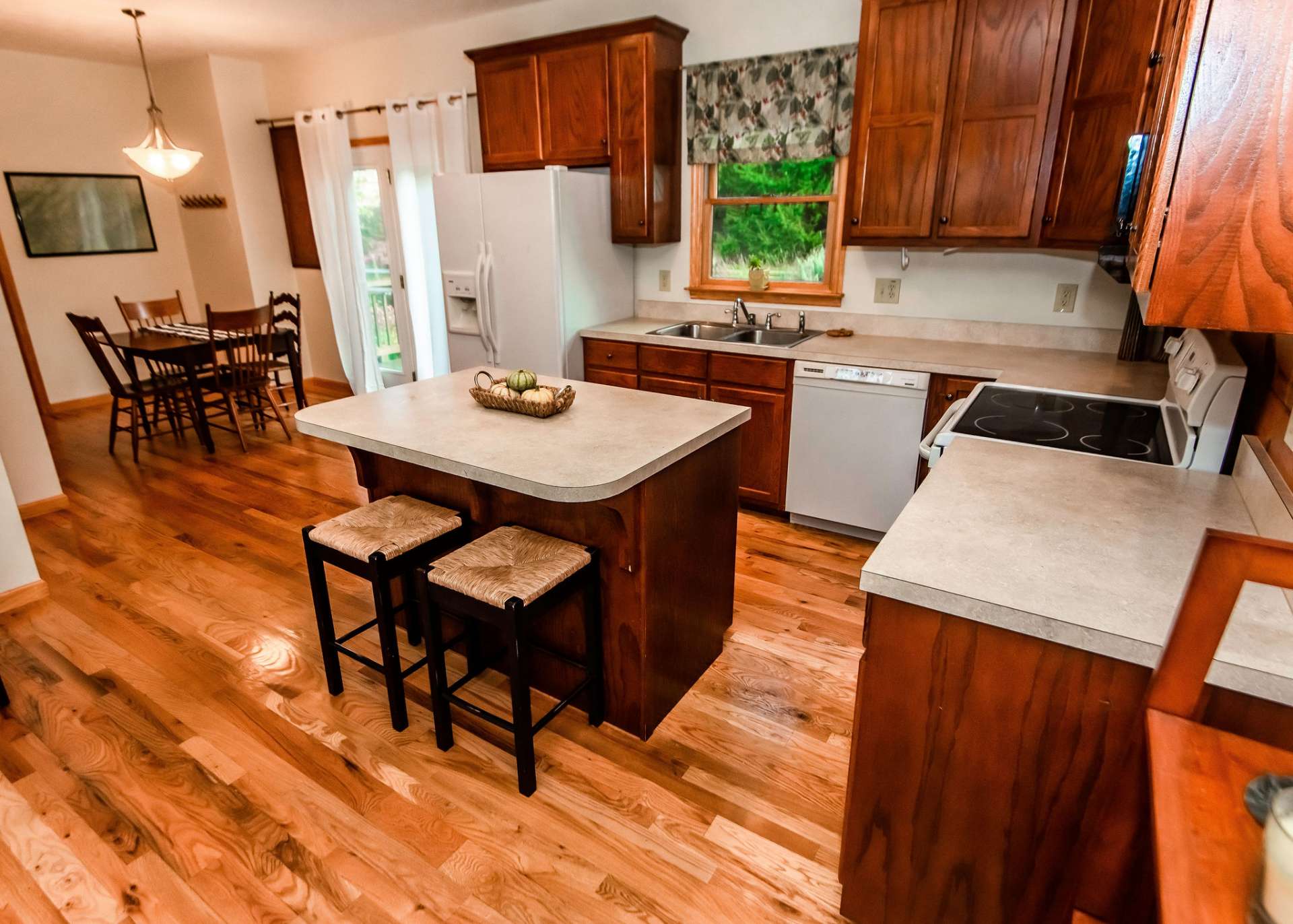 The kitchen offers ample work and storage space that includes a bar with seating.