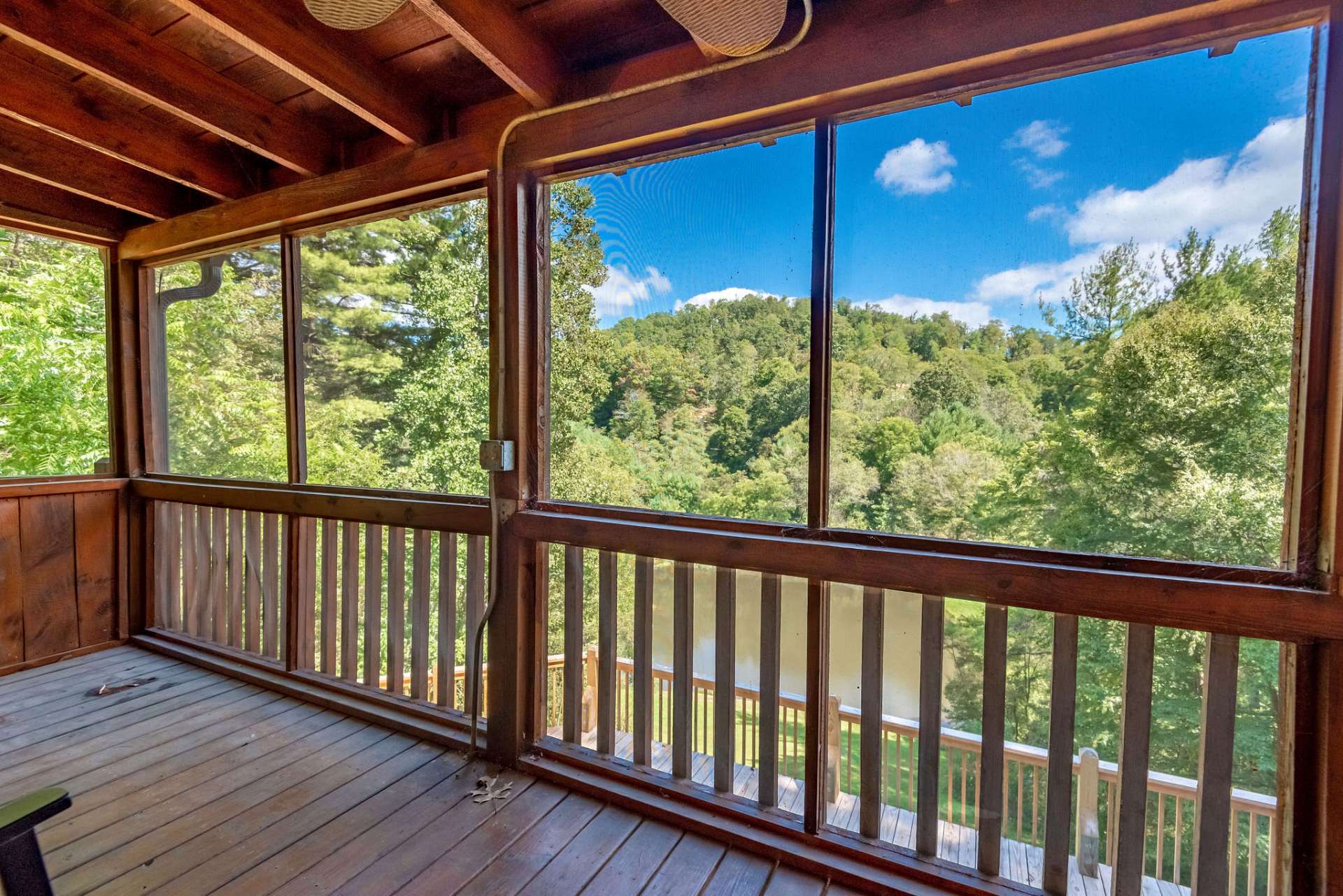 The covered screened in front porch is an extension of main level living area, and has a fabulous pond and mountain view.