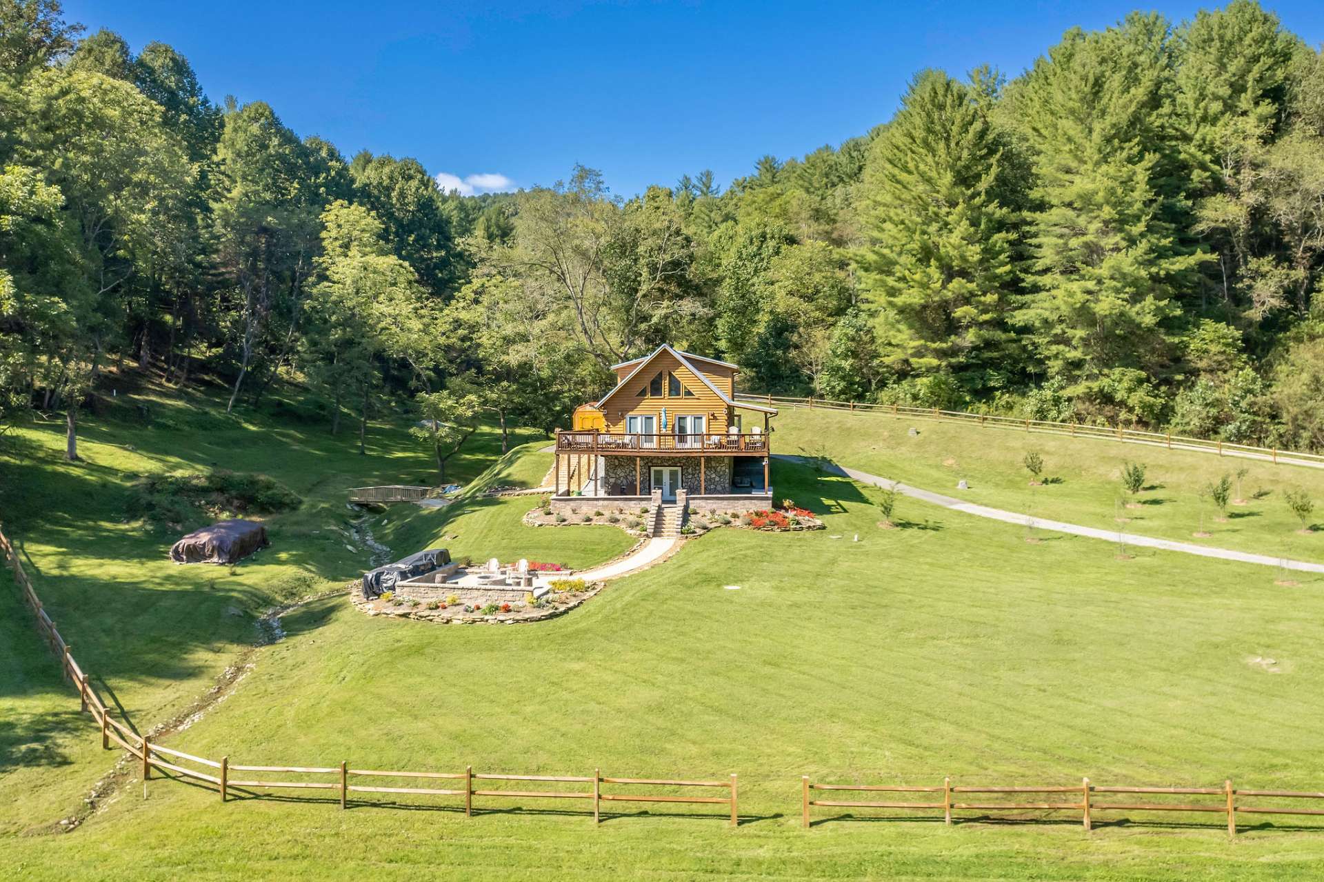This charming 3-bedroom, 3-bath log cabin is nestled among a 2.44 acre park-like setting in NC Dreams, a private community in the Grassy Creek area of Ashe County.