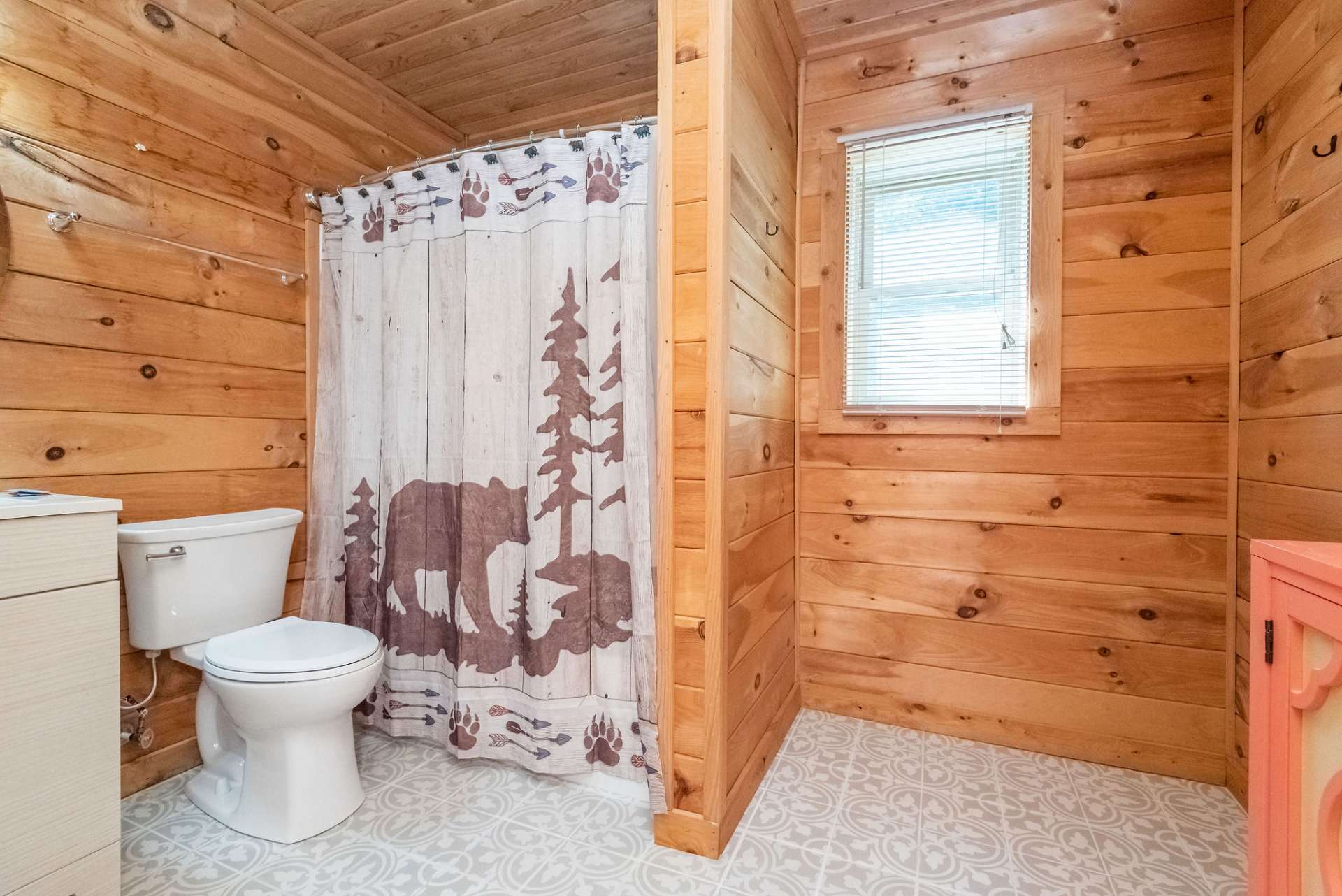 Full master bath with shower tub combo and tile flooring.