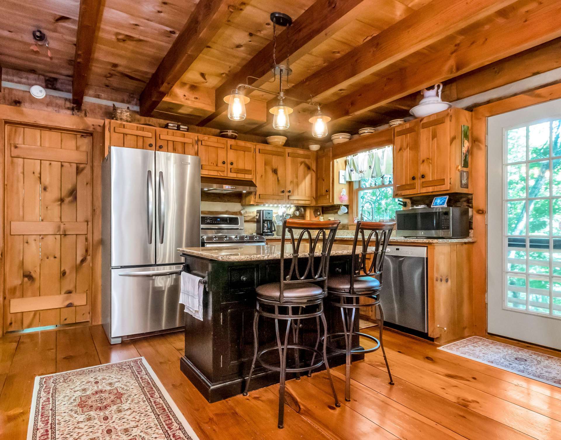 The kitchen's center island offers additional counter space and is perfect for informal dining and is a prime gathering spot.