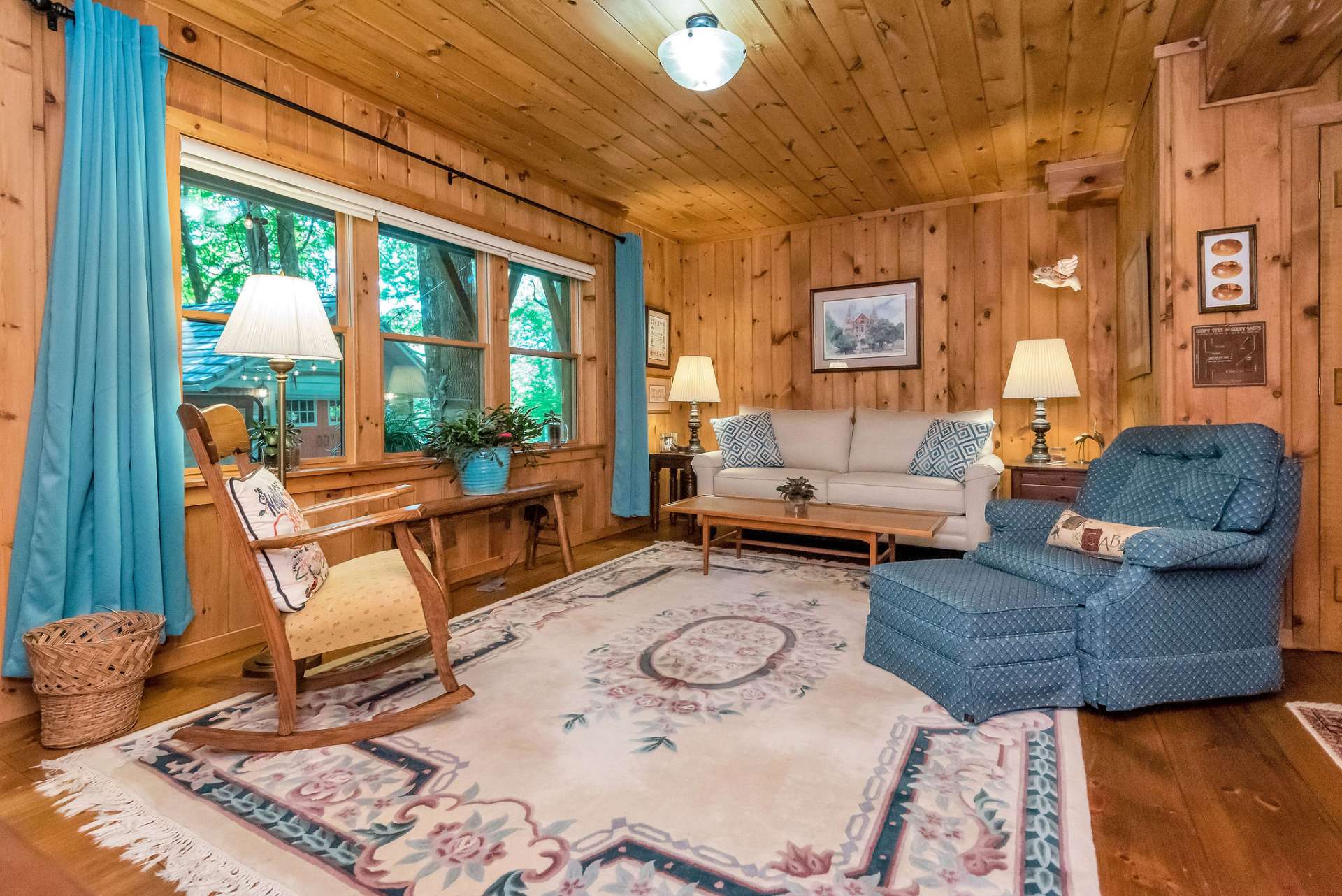 Lower level family room offers additional living space with large picture window to appreciate the natural setting. Custom blackout shades will convey with cabin.