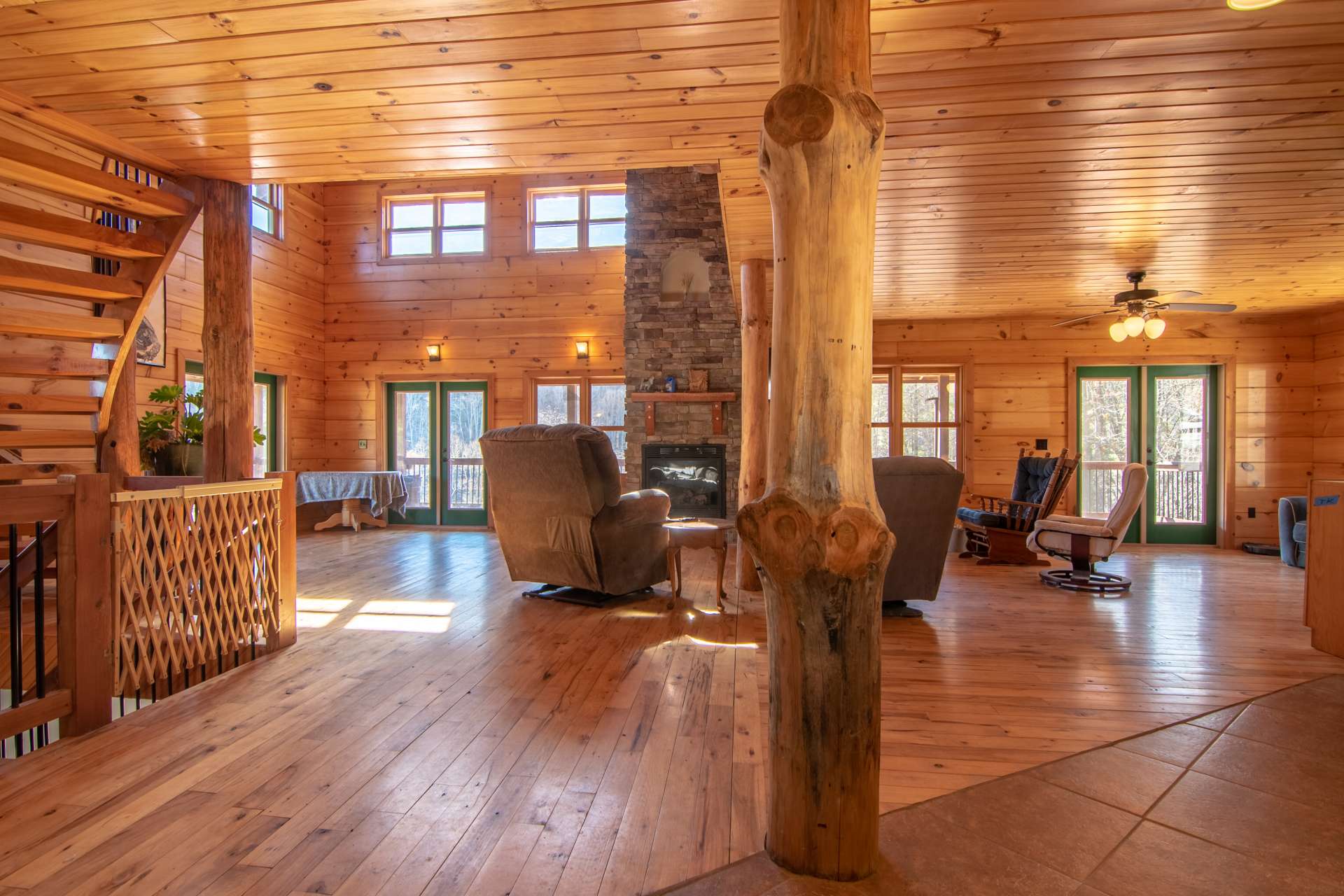 A soaring two story stone fireplace with gas logs provides added warmth and ambiance on cool winter evenings.  Beautiful hardwood floors gleam with the light from all of the windows.