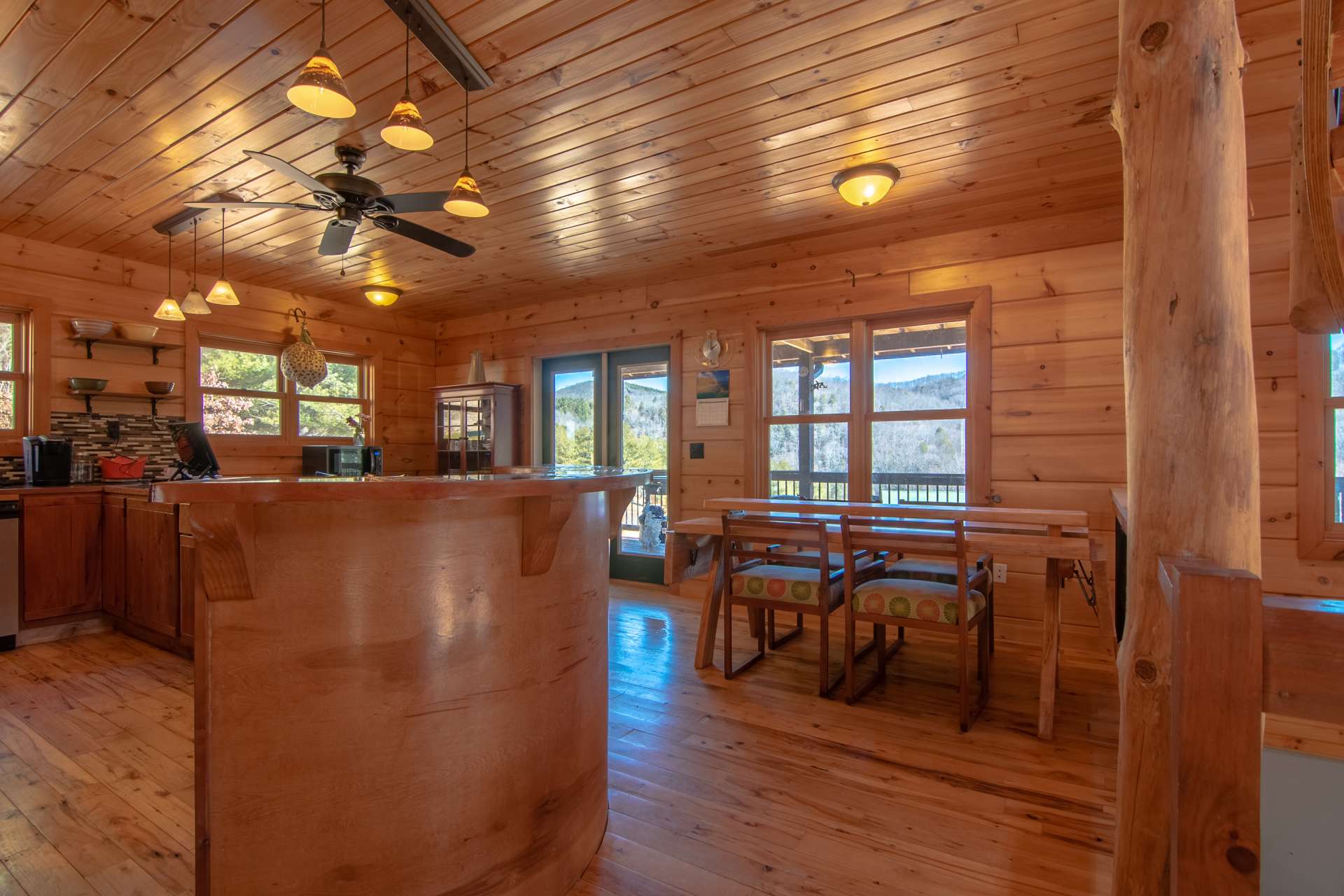 The living area is open to the kitchen and dining areas.  Notice the interesting bar with room for bar seating, perfect for those quick meals on the go, and also adding additional seating when entertaining.