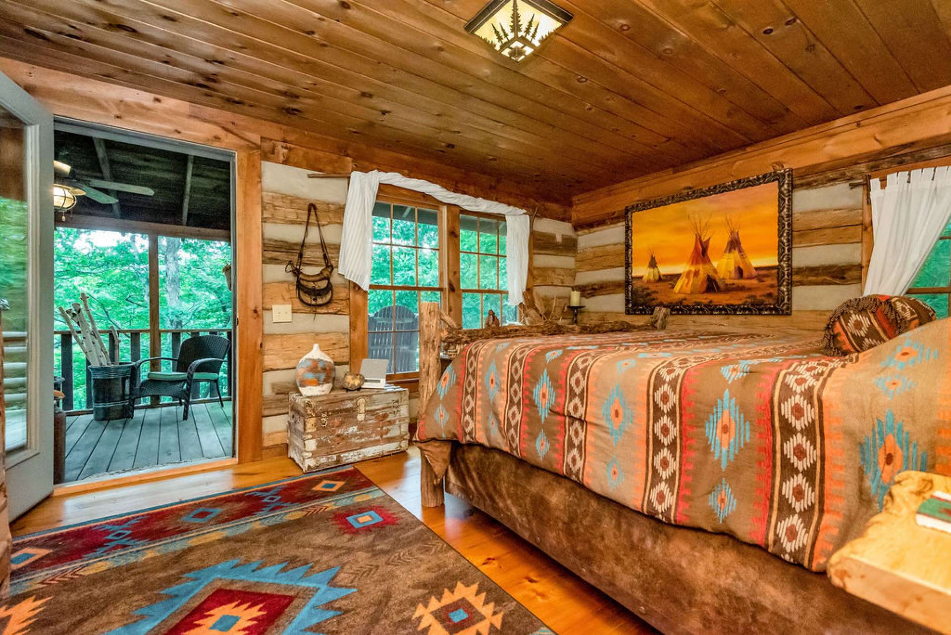 Spacious primary bedroom offers access to the screened in porch and back deck.